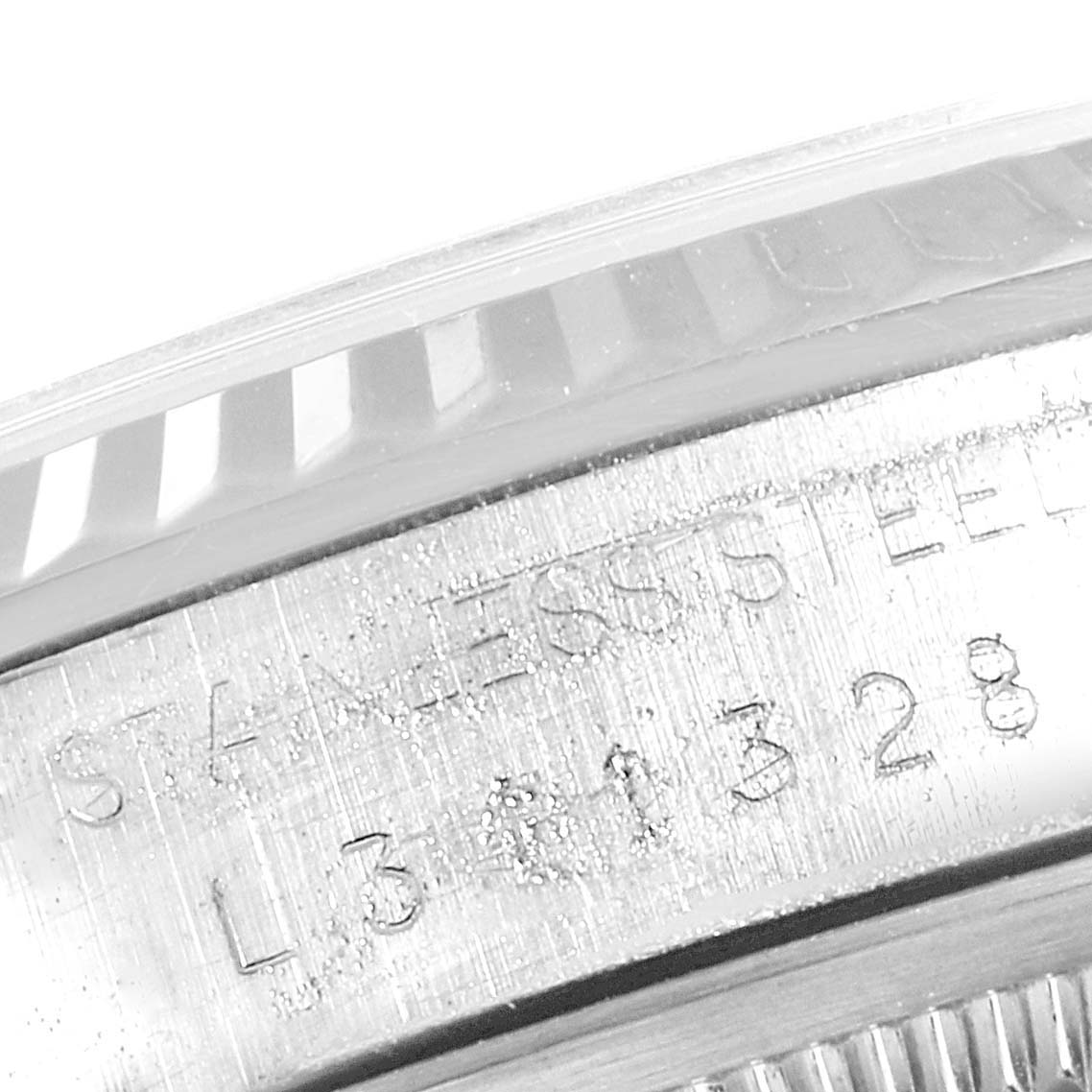 This image shows a close-up of the Rolex Datejust 16234 Men's Stainless Steel Silver Dial 16234 Men's Stainless Steel Silver Dial watch's fluted bezel and part of its stainless steel case with engraved details.