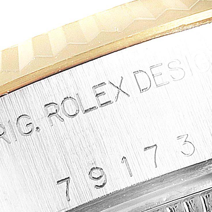 This close-up image shows part of the case and the engraved serial number of a Rolex Datejust 79173 Women
s Steel and Gold (two tone) Champagne Dial 79173 Women
s Steel and Gold (two tone) Champagne Dial watch.