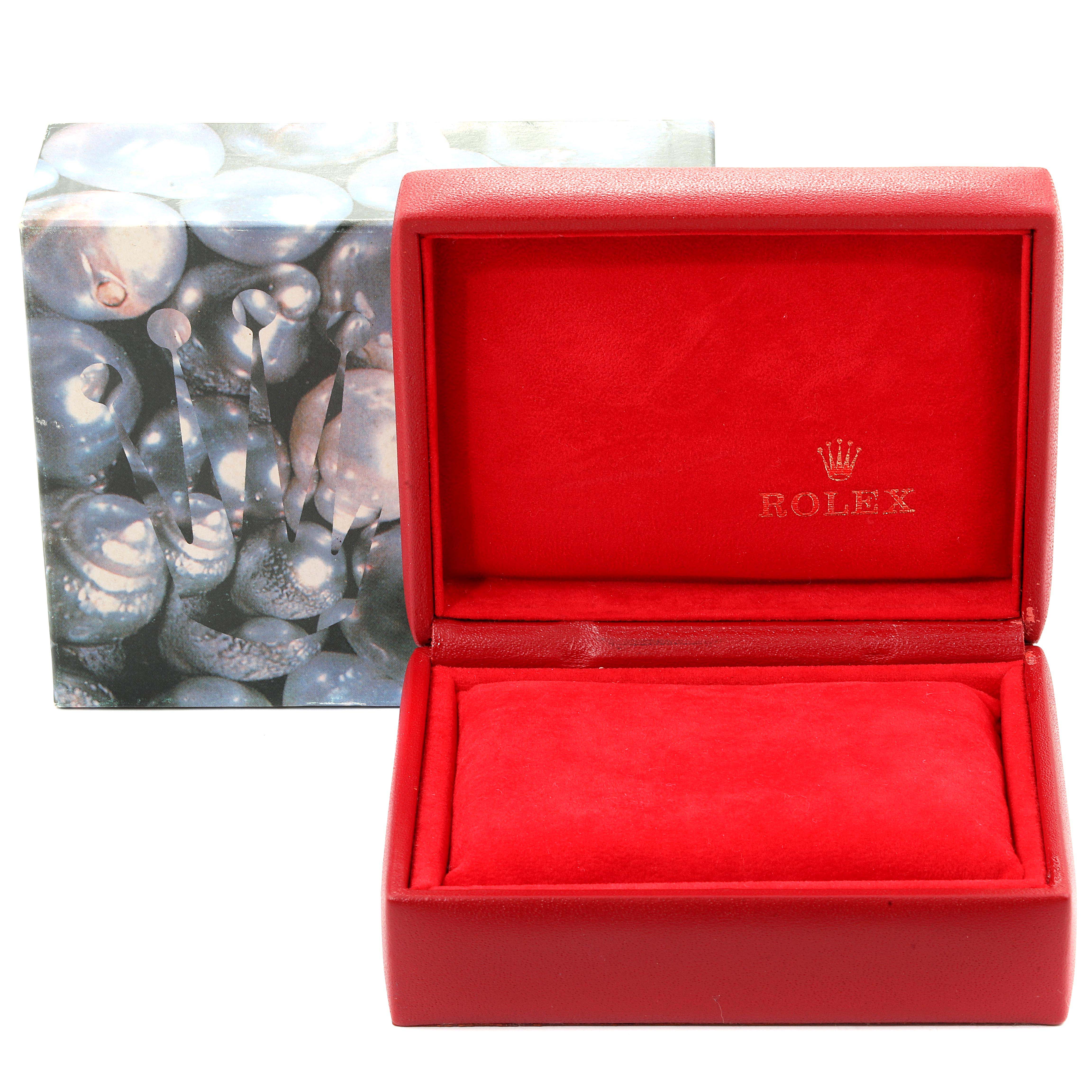 The image shows an open, red Rolex watch box for the Datejust model, positioned next to its outer decorative box.
