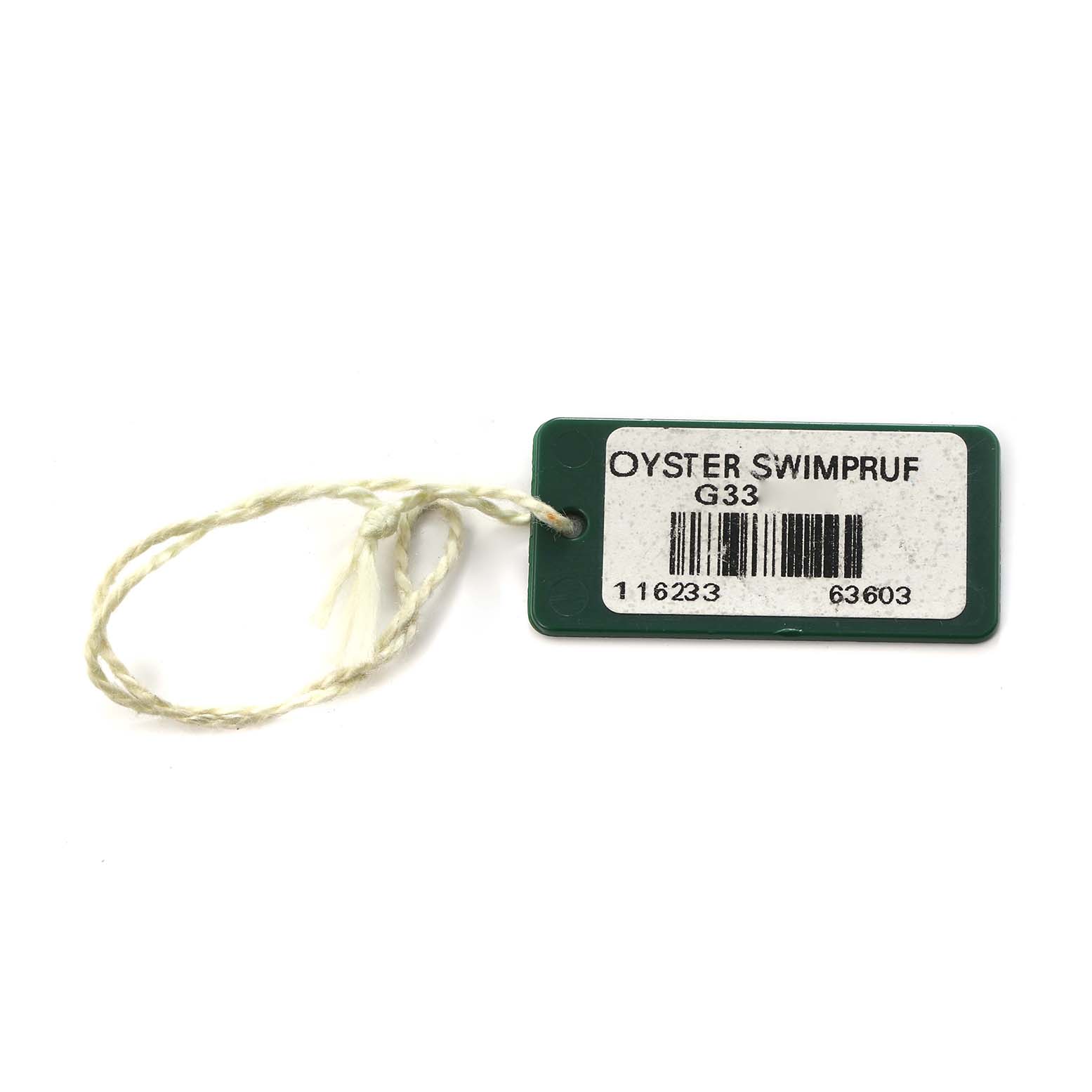 The image shows a green Rolex Datejust 116233 Men
s Steel and Gold (two tone) Champagne Dial 116233 Men
s Steel and Gold (two tone) Champagne Dial model Oyster Swimpruf hang tag with a string, lying flat.