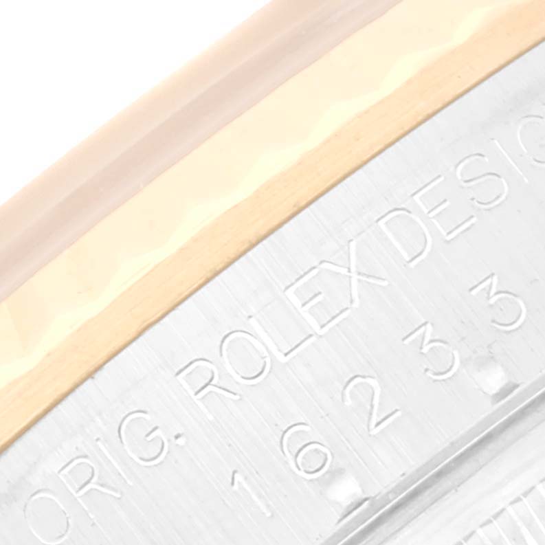 This extreme close-up shows a partial view of the bezel and casing of the Rolex Datejust 16233 Men's Steel and Gold (two tone) White Dial 16233 Men's Steel and Gold (two tone) White Dial watch, highlighting engraved text.
