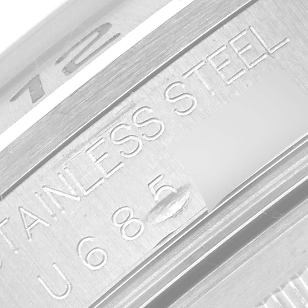 This close-up image of a Rolex Explorer 16570 Men
s Stainless Steel Black Dial 16570 Men
s Stainless Steel Black Dial model shows the "Stainless Steel" engraving and part of the engraved serial number on the watch case.