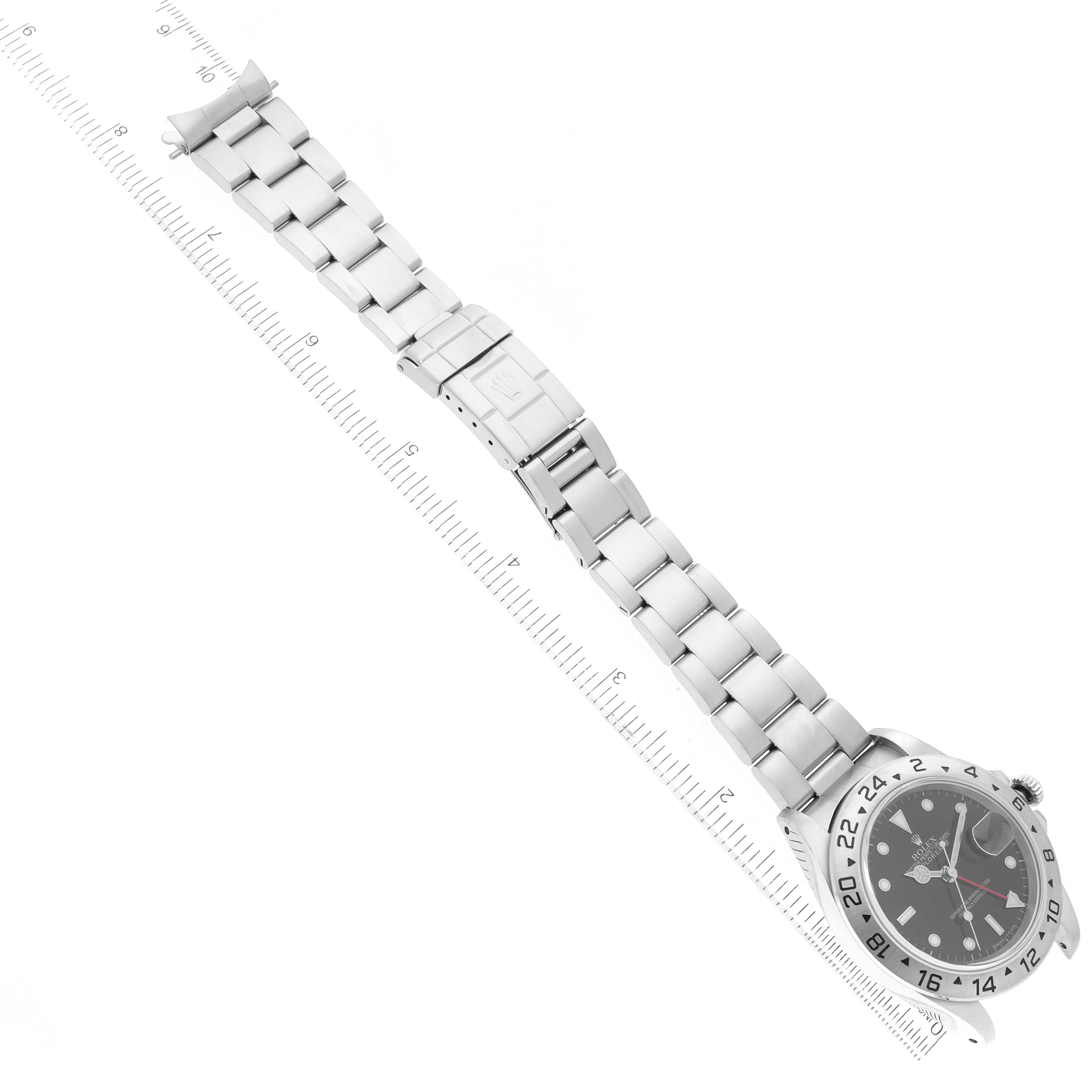 The Rolex Explorer 16570 Men
s Stainless Steel Black Dial 16570 Men
s Stainless Steel Black Dial watch is shown from an aerial view, highlighting the full bracelet and face with a ruler for scale.