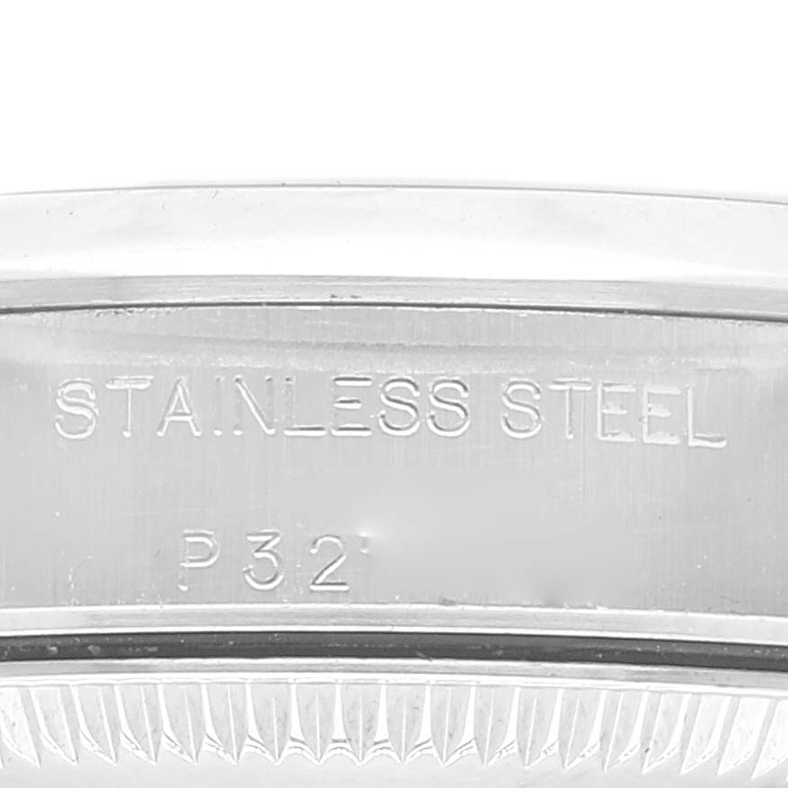This close-up image shows the engraving on the stainless steel casing of a Rolex Oyster Perpetual 76080 Women's Stainless Steel Blue Dial 76080 Women's Stainless Steel Blue Dial watch.