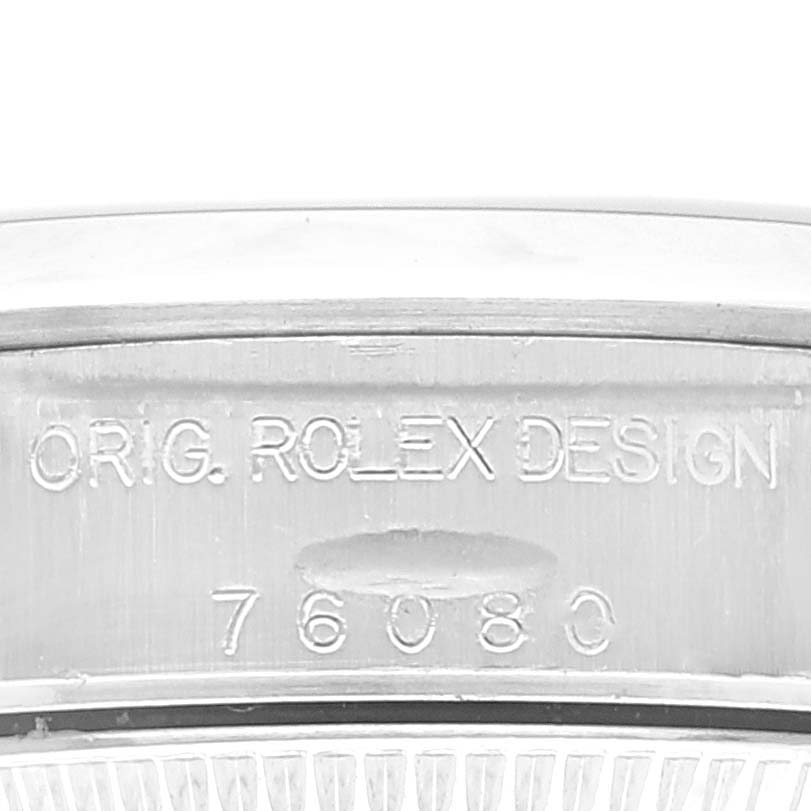 This is a close-up shot of the case side of the Rolex Oyster Perpetual 76080 Women's Stainless Steel Blue Dial 76080 Women's Stainless Steel Blue Dial, showing the serial number and "ORIG. ROLEX DESIGN" engraving.