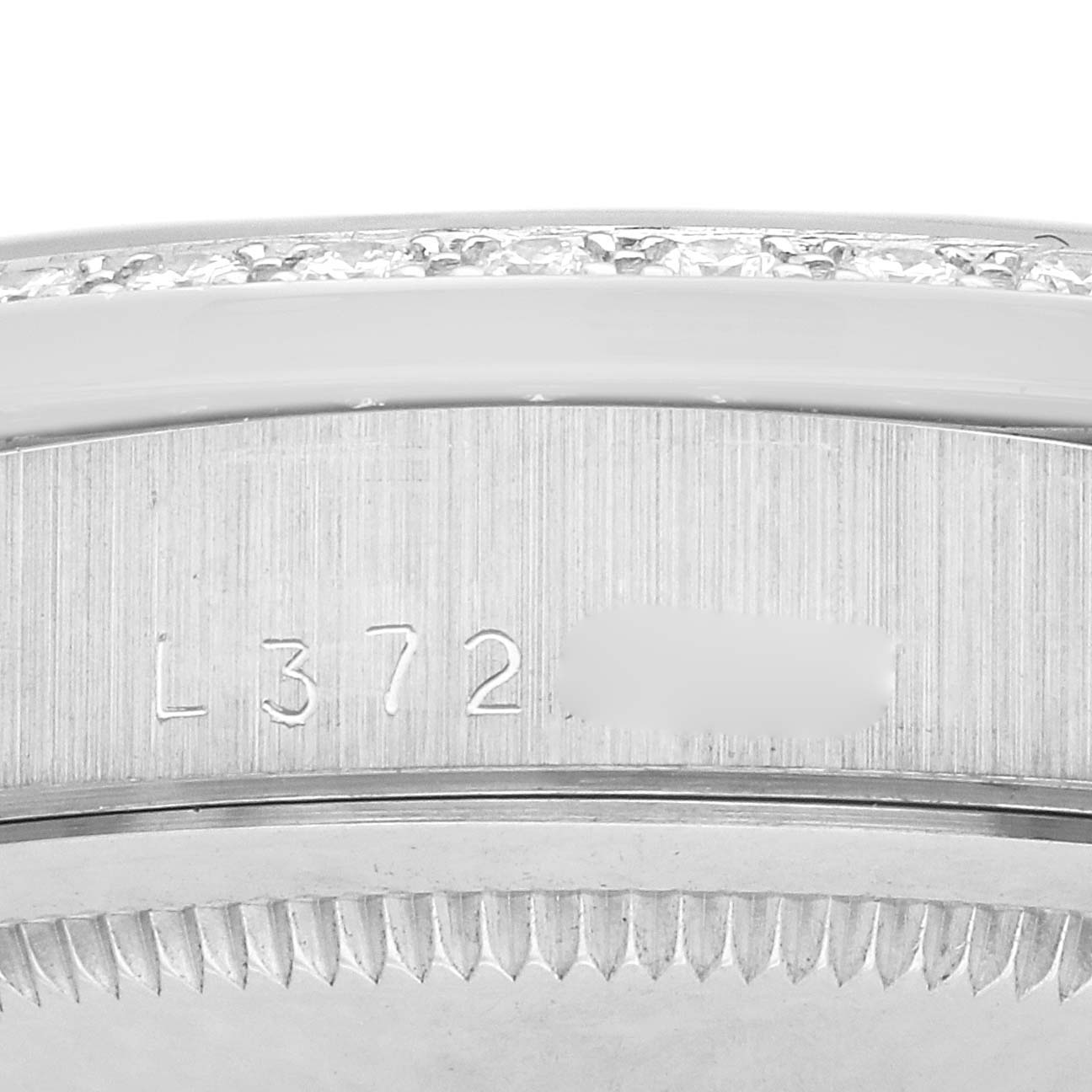 The image shows a close-up of the side of a Rolex President 18349 Men
s White Gold Silver Dial 18349 Men
s White Gold Silver Dial model, focusing on the serial number and bezel edge.
