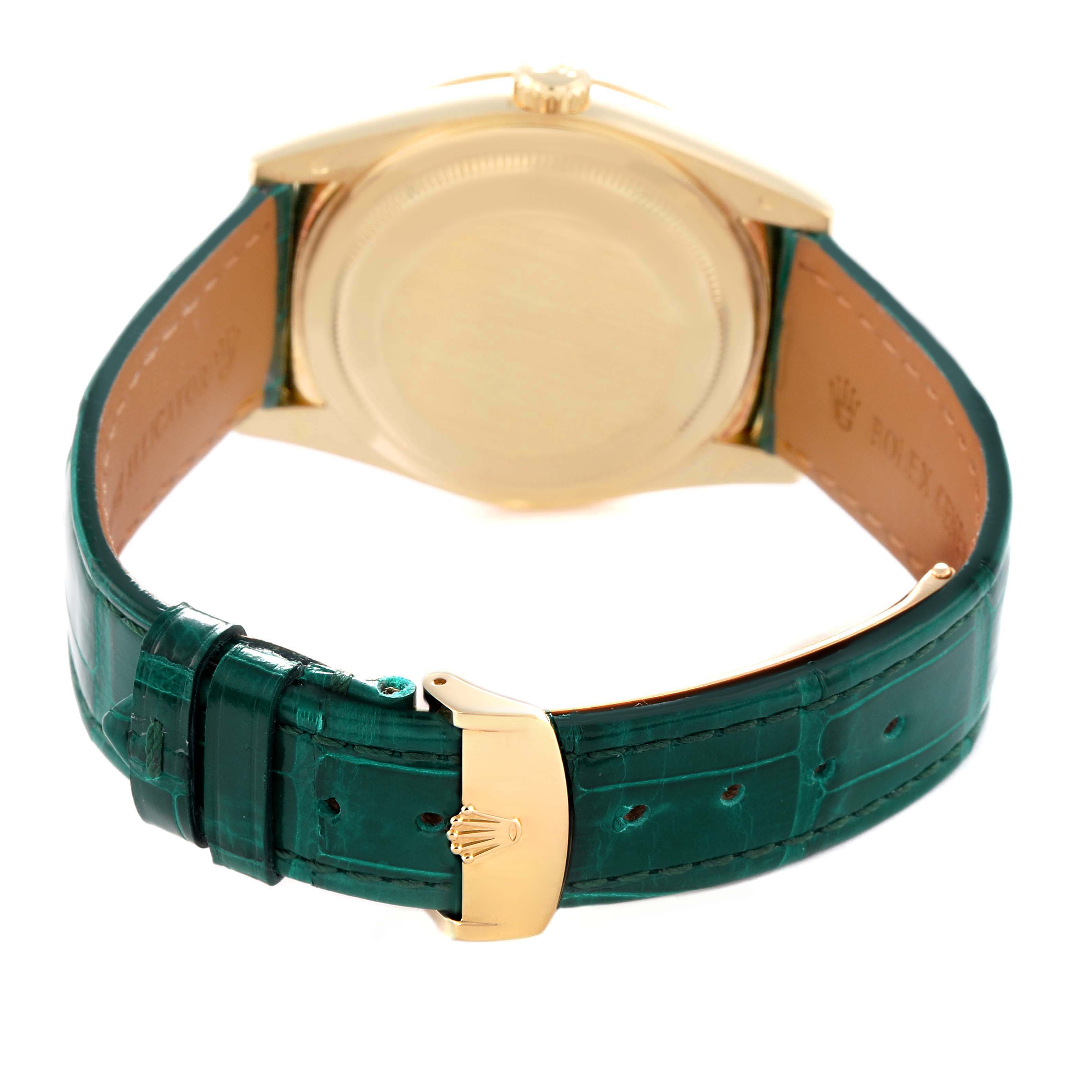 The image shows the back and underside of a Rolex President 118138 Men
s Yellow Gold Green Dial 118138 Men
s Yellow Gold Green Dial model watch with a green leather strap and gold clasp.