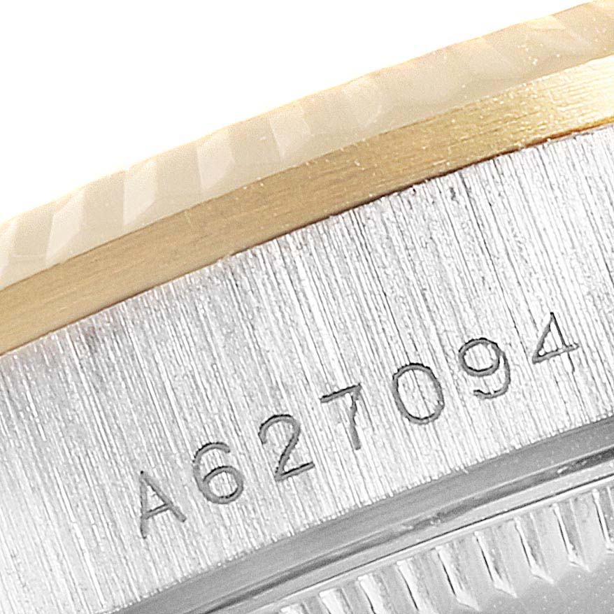 This close-up image of a Rolex President 78279 Women
s White Gold Brown Dial 78279 Women
s White Gold Brown Dial watch shows part of its bezel and serial number.