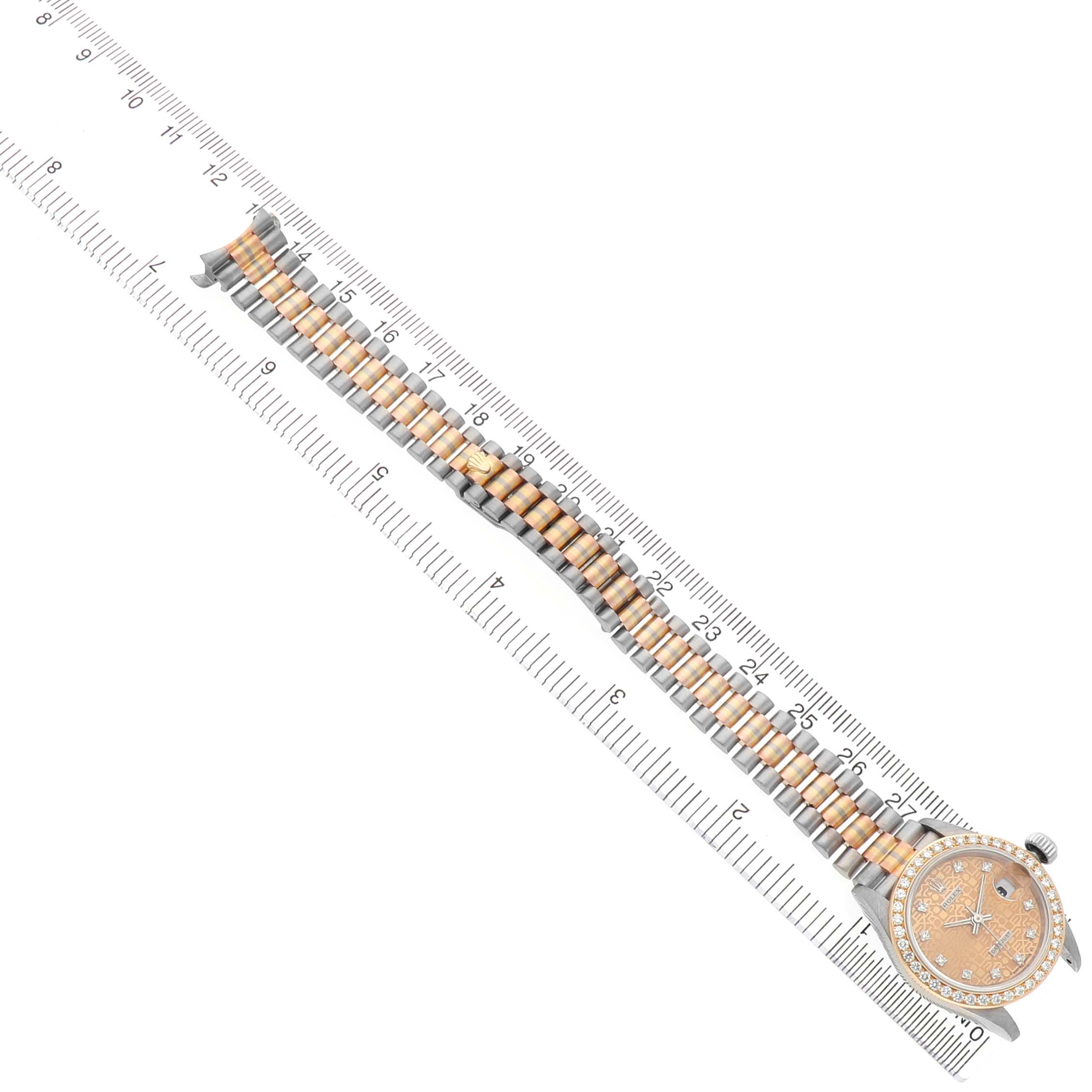The Rolex President 69139 Women's White Gold Champagne Dial model watch is shown from a top-down angle, displaying the face, dial, and entire bracelet laid along a ruler.