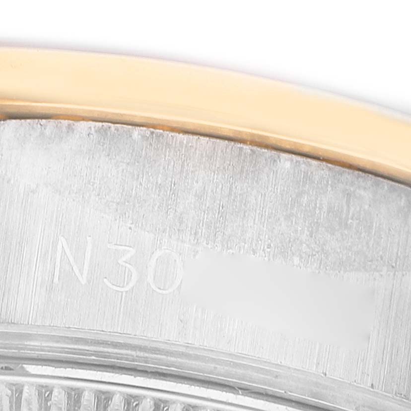 The image shows a close-up of the edge and serial engraving of the Rolex President 69139 Women's White Gold Champagne Dial watch.