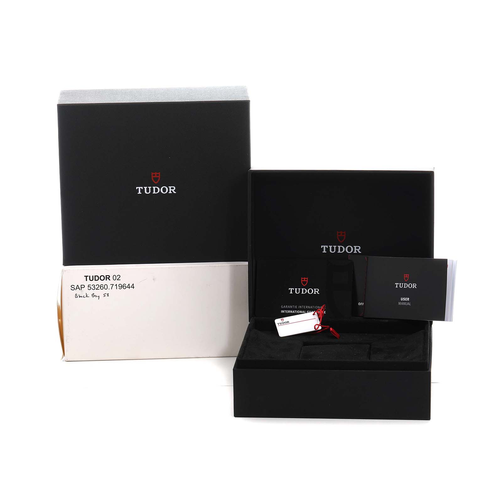 The image shows the packaging and accessories for a Tudor Heritage Black Bay 79030 Men's Stainless Steel Black Dial watch, including the box and booklets.