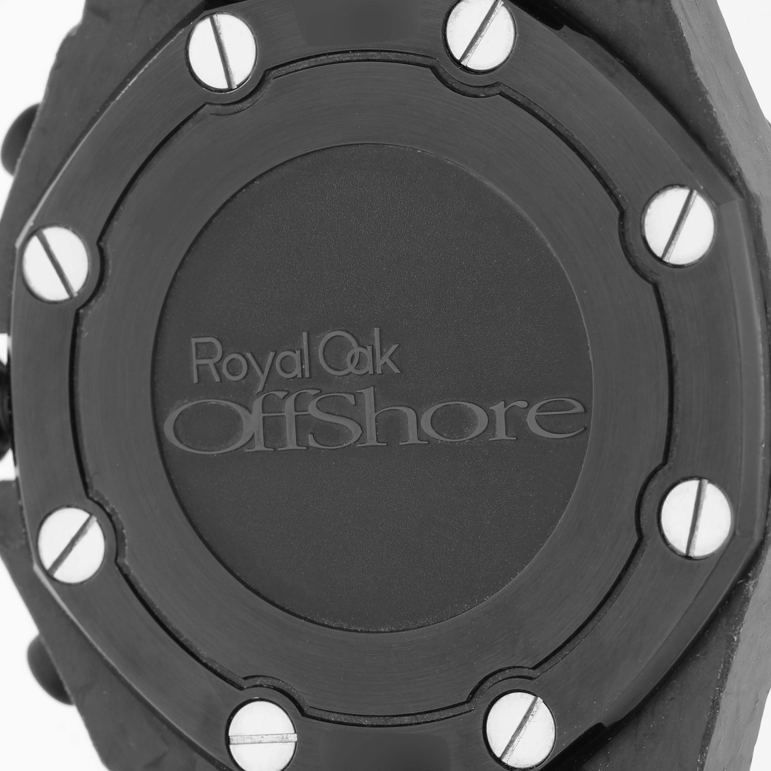 The image shows a close-up of the case back of an Audemars Piguet Royal Oak Offshore 26176FO.OO.D101CR.02 Men
s Ceramic Black Dial 26176FO.OO.D101CR.02 Men
s Ceramic Black Dial, focusing on the engraved logo and screws.
