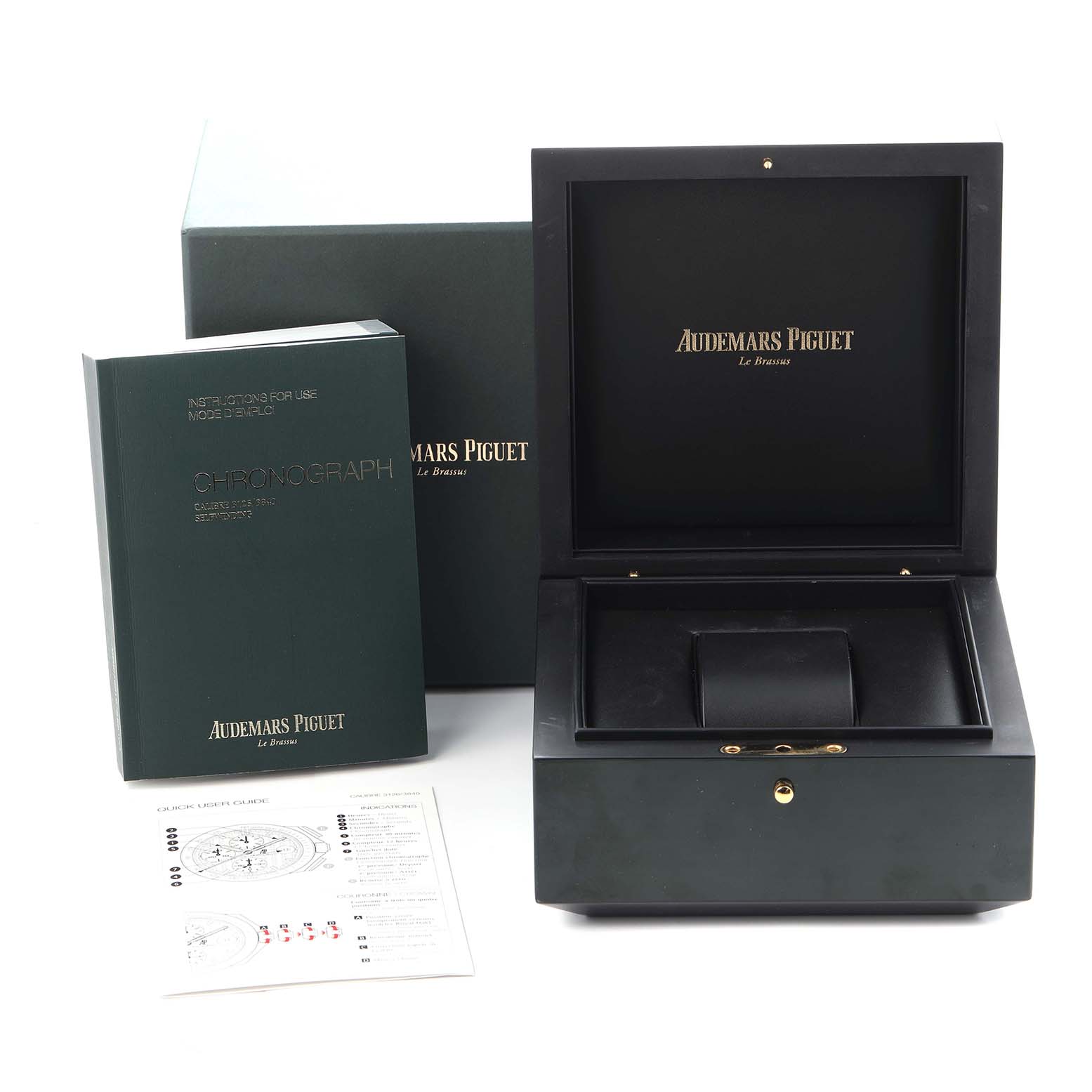 The image shows the Audemars Piguet Royal Oak packaging, including a box, instruction manual, and paperwork, viewed from the front.