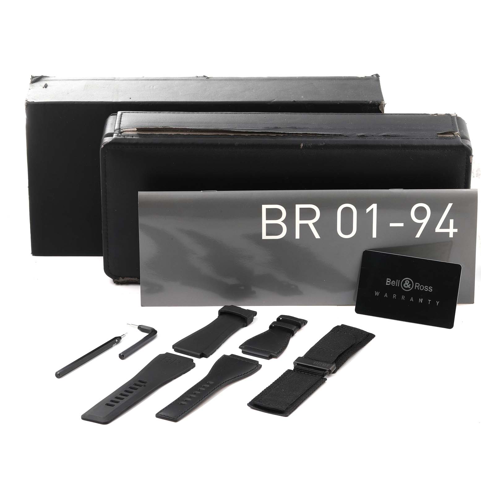 The image shows accessories for the Bell & Ross Chronograph BR 01-94, including straps, tools, and a warranty card.
