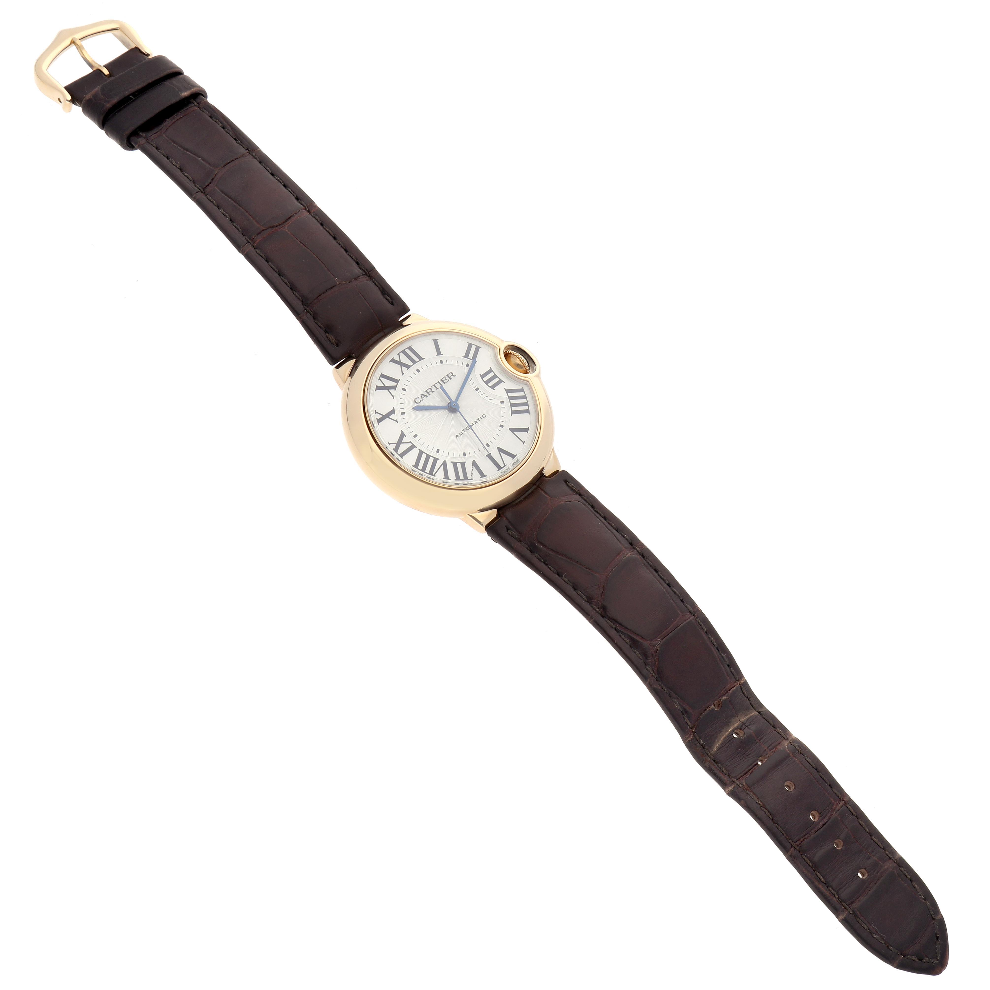 The Cartier Ballon Bleu W6900356 Men
s Yellow Gold Silver Dial W6900356 Men
s Yellow Gold Silver Dial watch is shown from a top view, displaying its round face, Roman numerals, and leather strap.