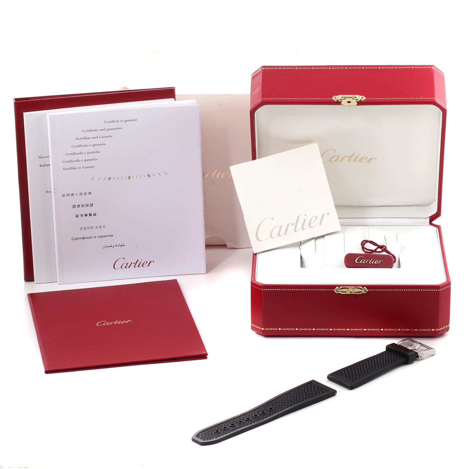 The image shows the packaging, warranty cards, and a black strap accessory for the Calibre de Cartier model by Cartier.