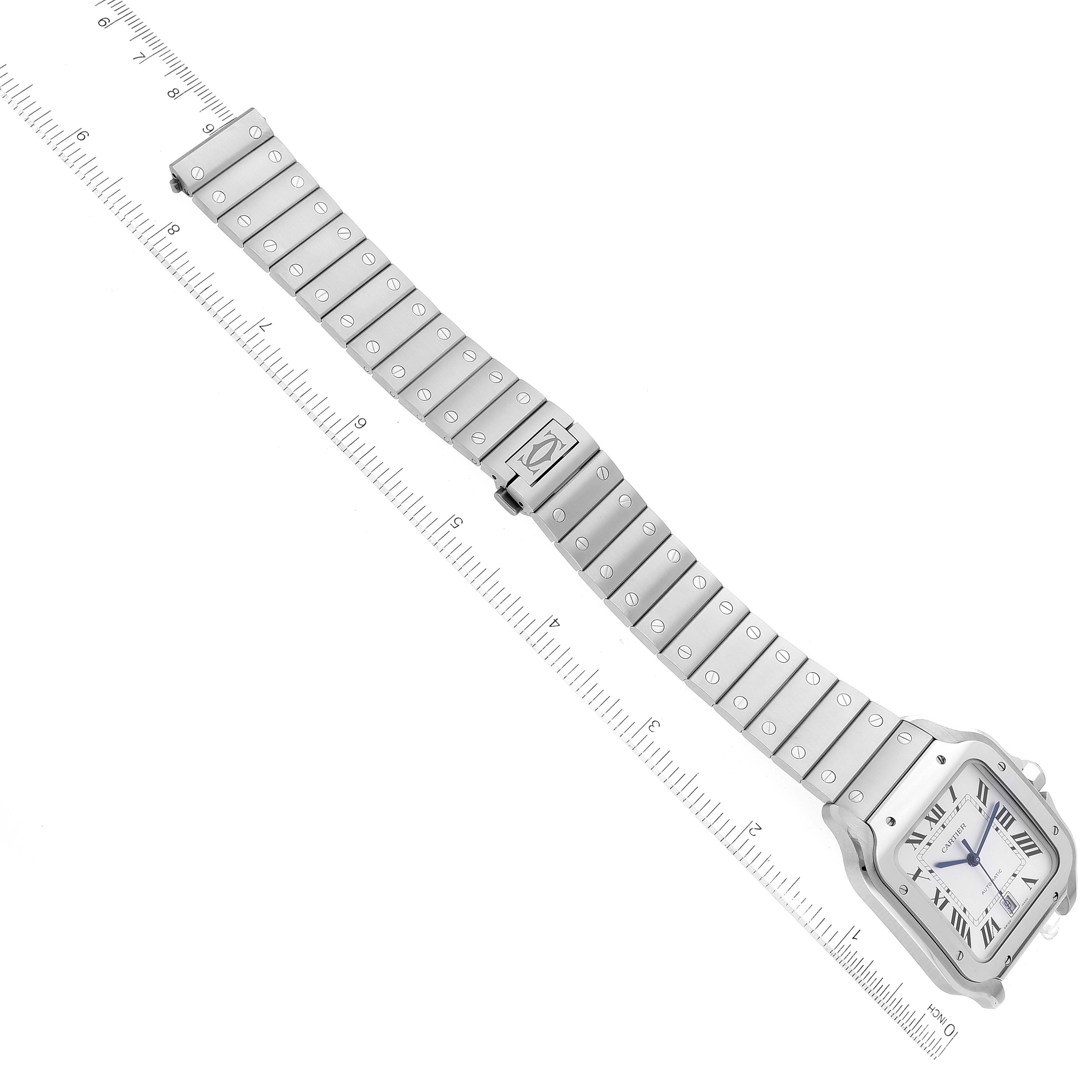 The image shows a Cartier Santos WSSA0018 Men
s Stainless Steel Silver Dial WSSA0018 Men
s Stainless Steel Silver Dial watch laid flat, displaying the full band and square watch face alongside a measuring ruler.