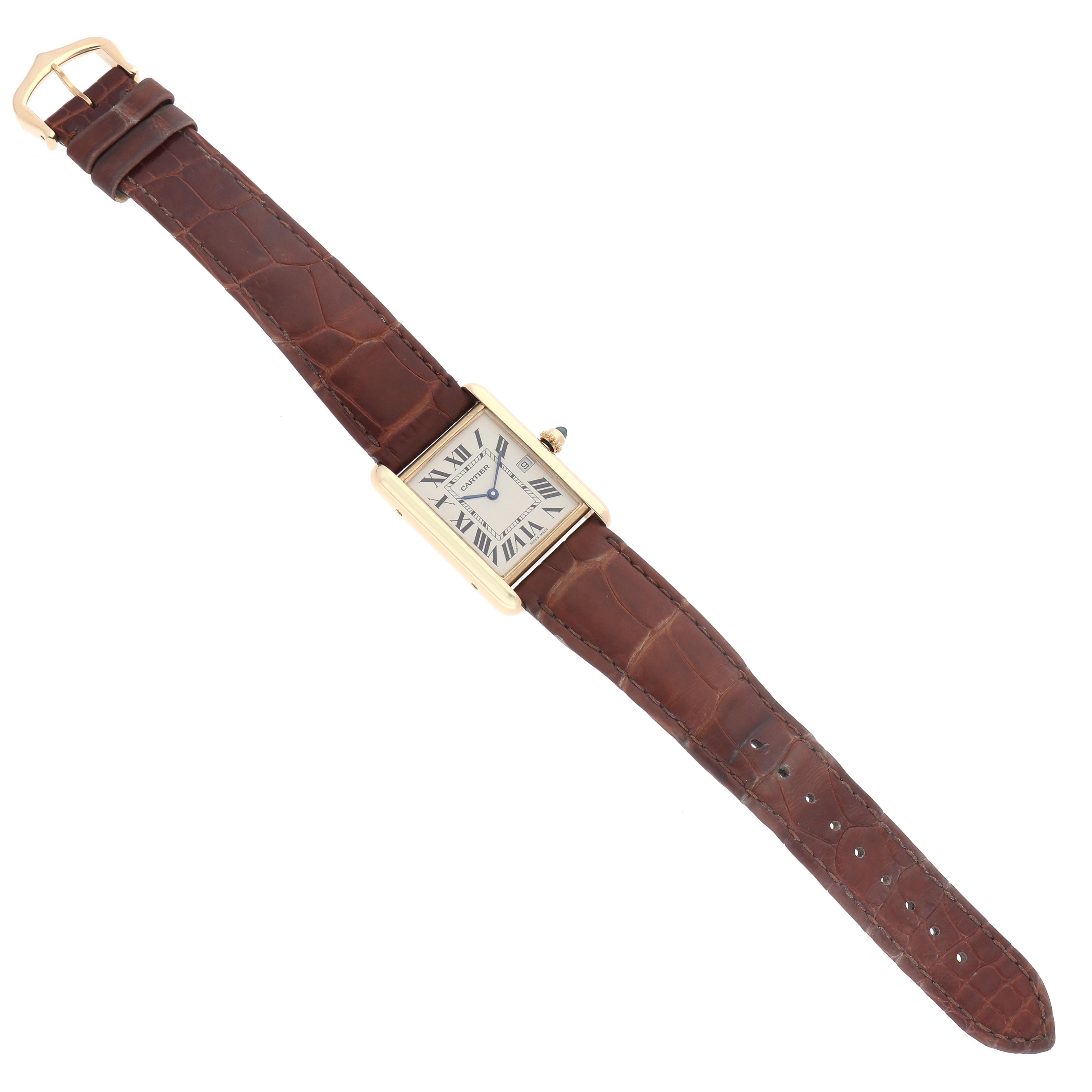 The Cartier Tank Louis W1529756 Men
s Yellow Gold Silver Dial W1529756 Men
s Yellow Gold Silver Dial watch is shown from a top-down angle, highlighting its rectangular face, brown leather strap, and gold case.