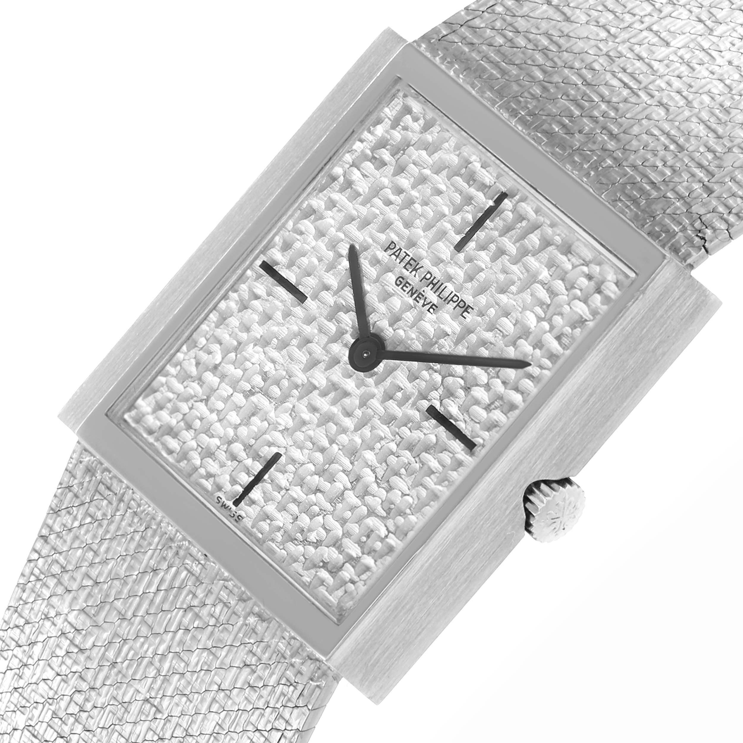 The Patek Philippe Vintage 3491/3 Women
s White Gold Silver Dial 3491/3 Women
s White Gold Silver Dial watch is shown at an angle highlighting the textured dial, rectangular case, and woven strap with a visible crown.