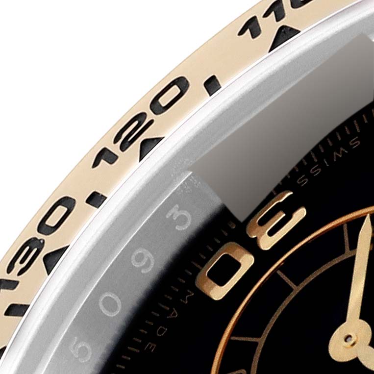 The image shows a close-up of the bezel and part of the dial of a Rolex Daytona 116503 Men
s Steel and Gold (two tone) Black Dial 116503 Men
s Steel and Gold (two tone) Black Dial watch.