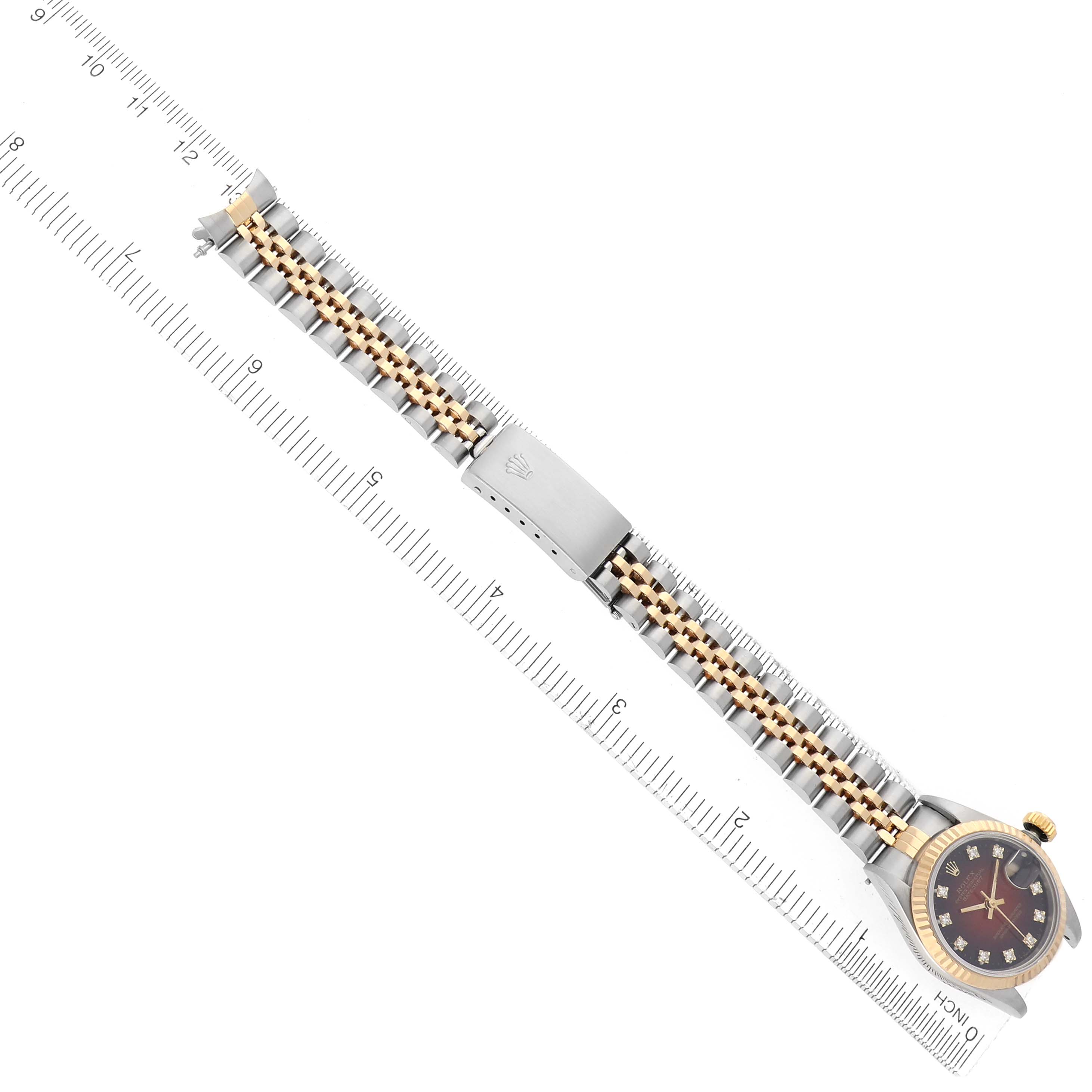 The Rolex Datejust 69173 Women
s Steel and Gold (two tone) Red Dial 69173 Women
s Steel and Gold (two tone) Red Dial watch is shown from a top-down angle, showcasing the full bracelet, clasp, and face with the crown.