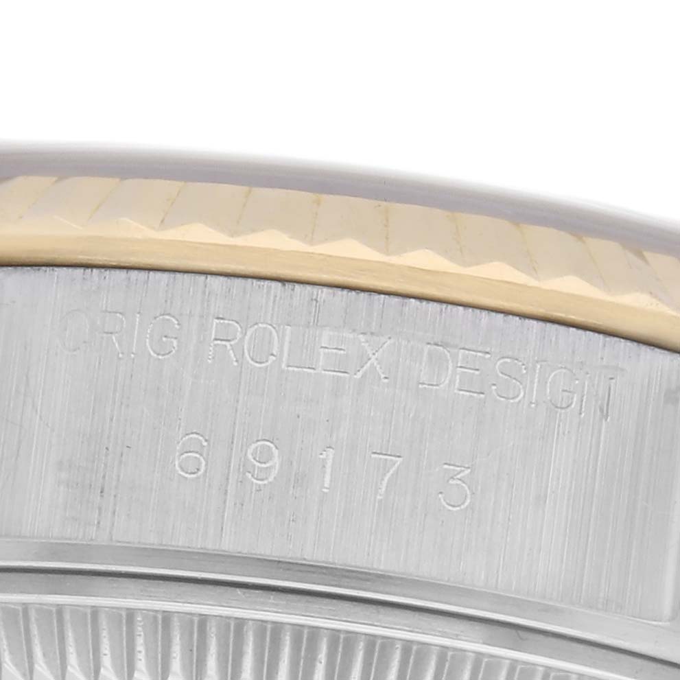 The image shows the engraved side of a Rolex Datejust 69173 Women
s Steel and Gold (two tone) Red Dial 69173 Women
s Steel and Gold (two tone) Red Dial watch, highlighting the model number "69173."