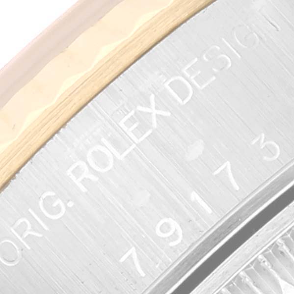 The image shows an angled close-up of the engraved text on the side of a Rolex Datejust 79173 Women's Steel and Gold (two tone) Blue Dial 79173 Women's Steel and Gold (two tone) Blue Dial model watch case.