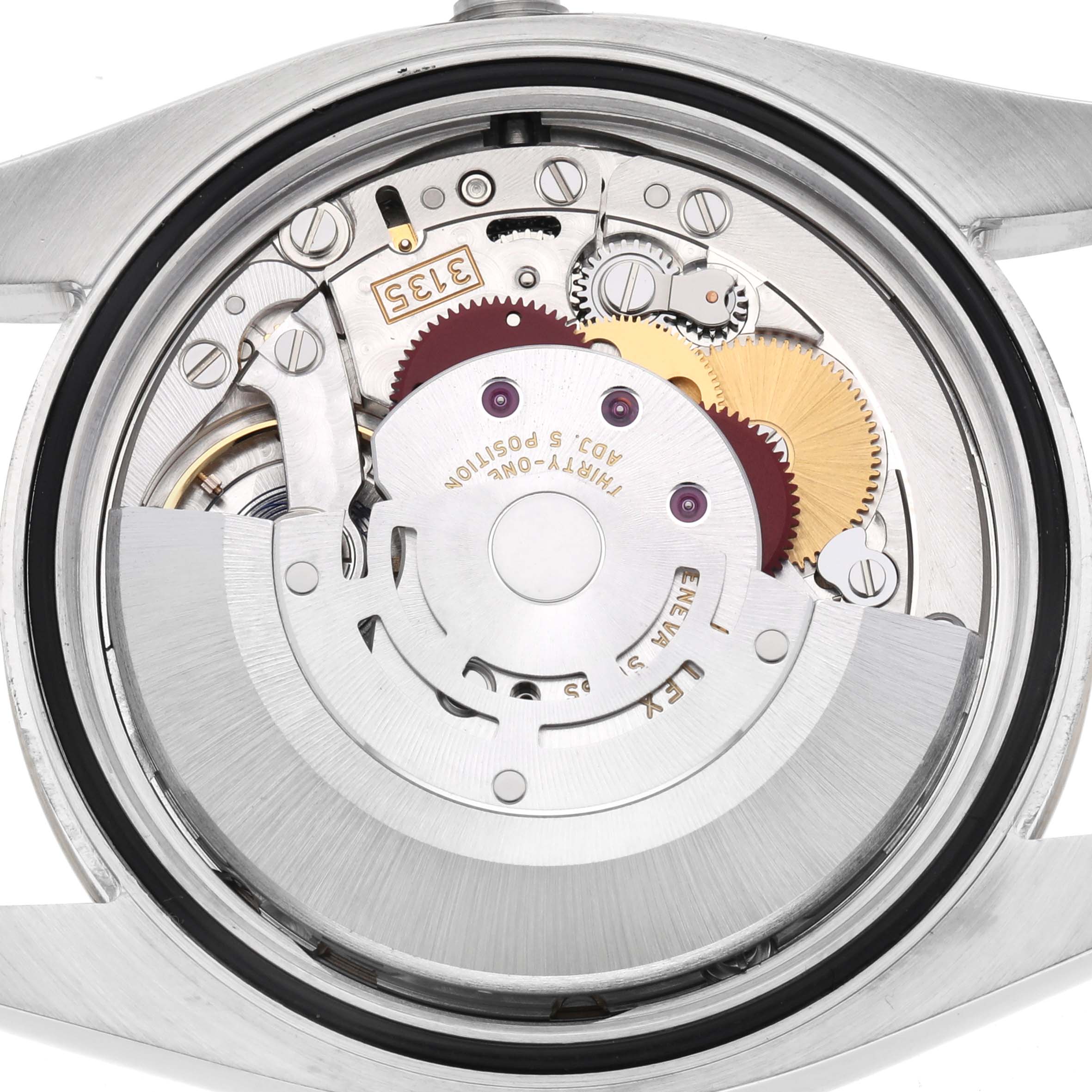 The image shows the movement of a Rolex Datejust 116233 Men
s Steel and Gold (two tone) Champagne Dial 116233 Men
s Steel and Gold (two tone) Champagne Dial watch from a back angle, highlighting the intricate gears and rotor.