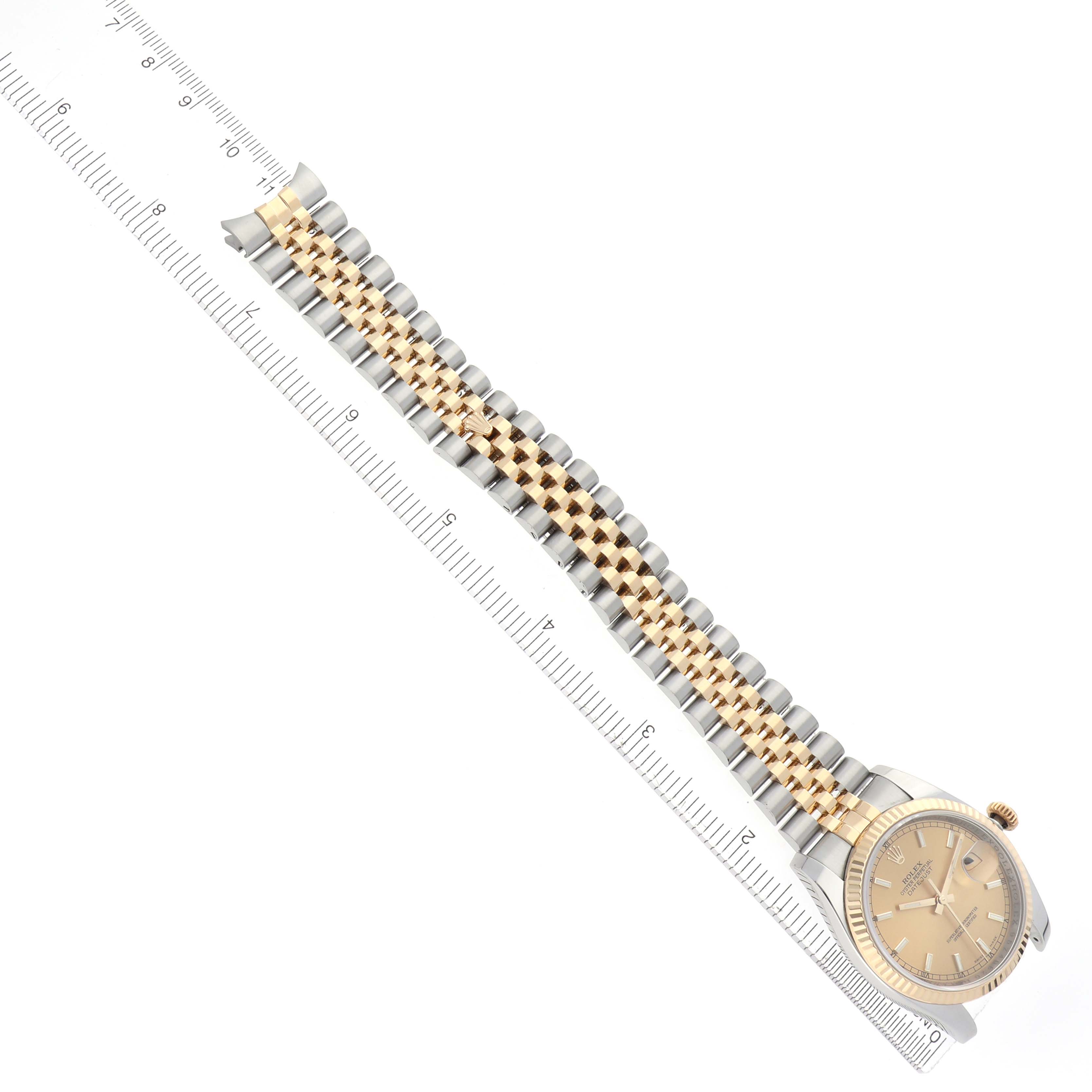 The image shows a Rolex Datejust 116233 Men
s Steel and Gold (two tone) Champagne Dial 116233 Men
s Steel and Gold (two tone) Champagne Dial watch at an angled top view, highlighting its face and two-tone bracelet.
