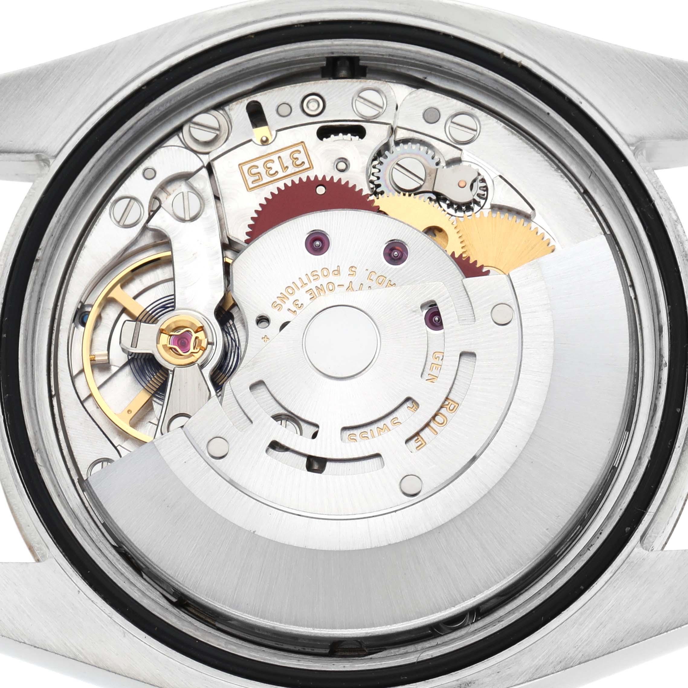 This image shows the movement of a Rolex Datejust 116233 Men
s Steel and Gold (two tone) Champagne Dial 116233 Men
s Steel and Gold (two tone) Champagne Dial from a rear angle, highlighting gears and the rotor.