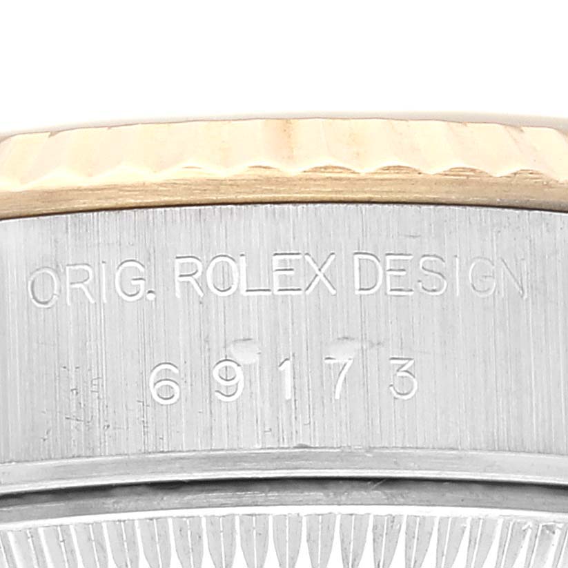 The image shows a close-up of the side of a Rolex Datejust 69173 Women's Steel and Gold (two tone) Champagne Dial 69173 Women's Steel and Gold (two tone) Champagne Dial watch, highlighting the engraved model number 69173 and the words "ORIG. ROLEX DESIGN."