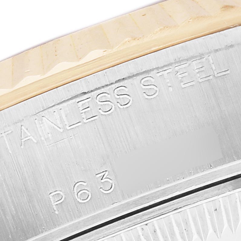 The image shows the engraved edge of a Rolex Datejust 79173 Women
s Steel and Gold (two tone) Mother of Pearl Dial 79173 Women
s Steel and Gold (two tone) Mother of Pearl Dial watch, highlighting the words "STAINLESS STEEL" and part of the bezel.