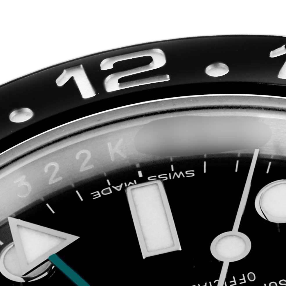 The image shows a close-up of the bezel and dial with a hand of the Rolex GMT-Master 116710 Men
s Stainless Steel Black Dial 116710 Men
s Stainless Steel Black Dial watch, focusing on the “12” marker.