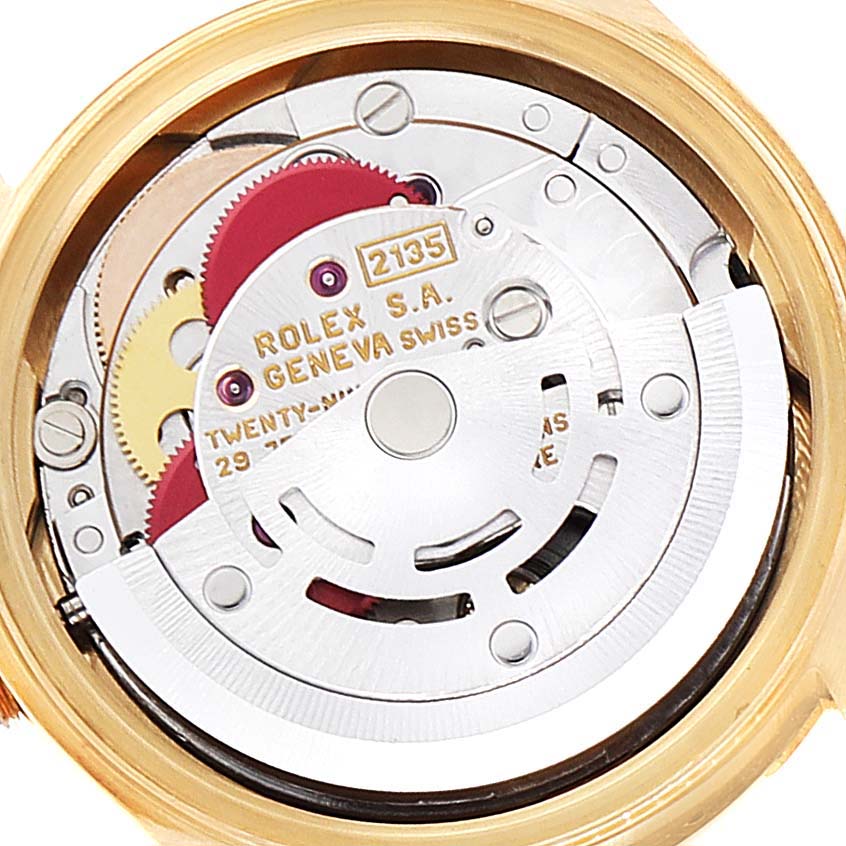 This image shows the movement mechanism of a Rolex President 69158 Women
s Yellow Gold Grey Dial 69158 Women
s Yellow Gold Grey Dial model watch with visible gears and the inscription.