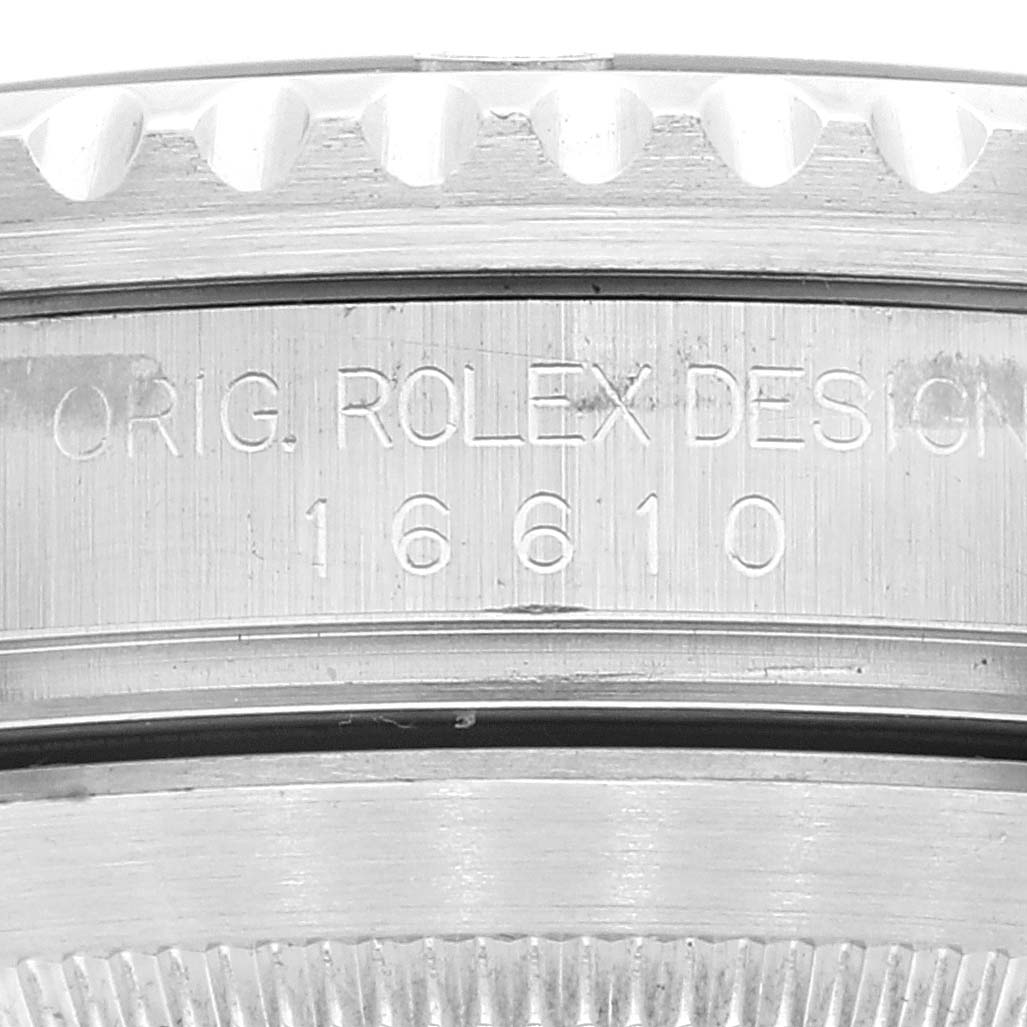 The image shows a close-up view of the bezel and case side of the Rolex Submariner 16610 Men
s Stainless Steel Black Dial 16610 Men
s Stainless Steel Black Dial model, displaying the engraving "ORIG. ROLEX DESIGN 16610."