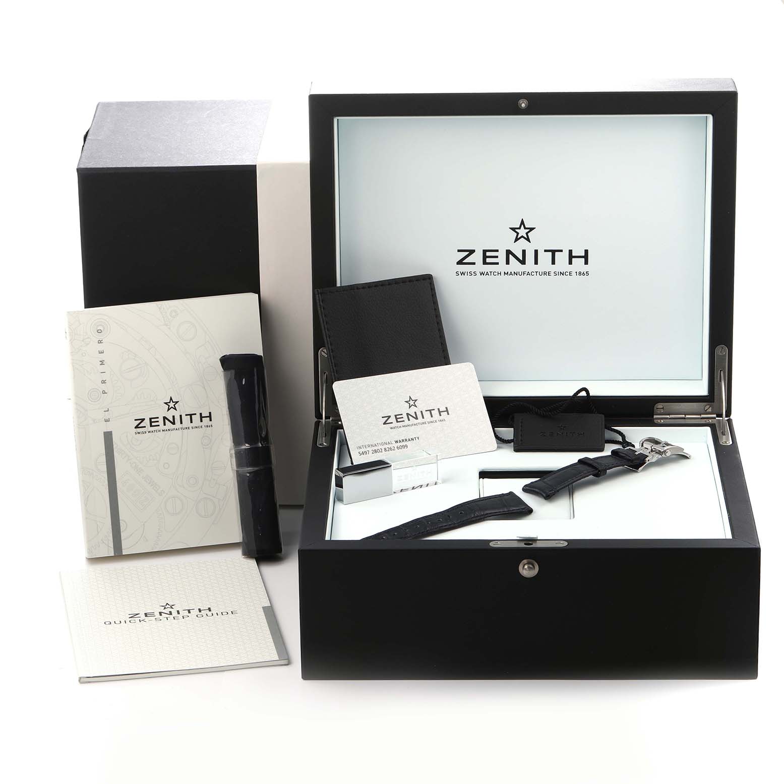 The image shows a Zenith Chronomaster 03.2150.400/53.C700 Men
s Stainless Steel Blue Dial 03.2150.400/53.C700 Men
s Stainless Steel Blue Dial presentation box with manuals, a strap, and accessories from an overhead angle.