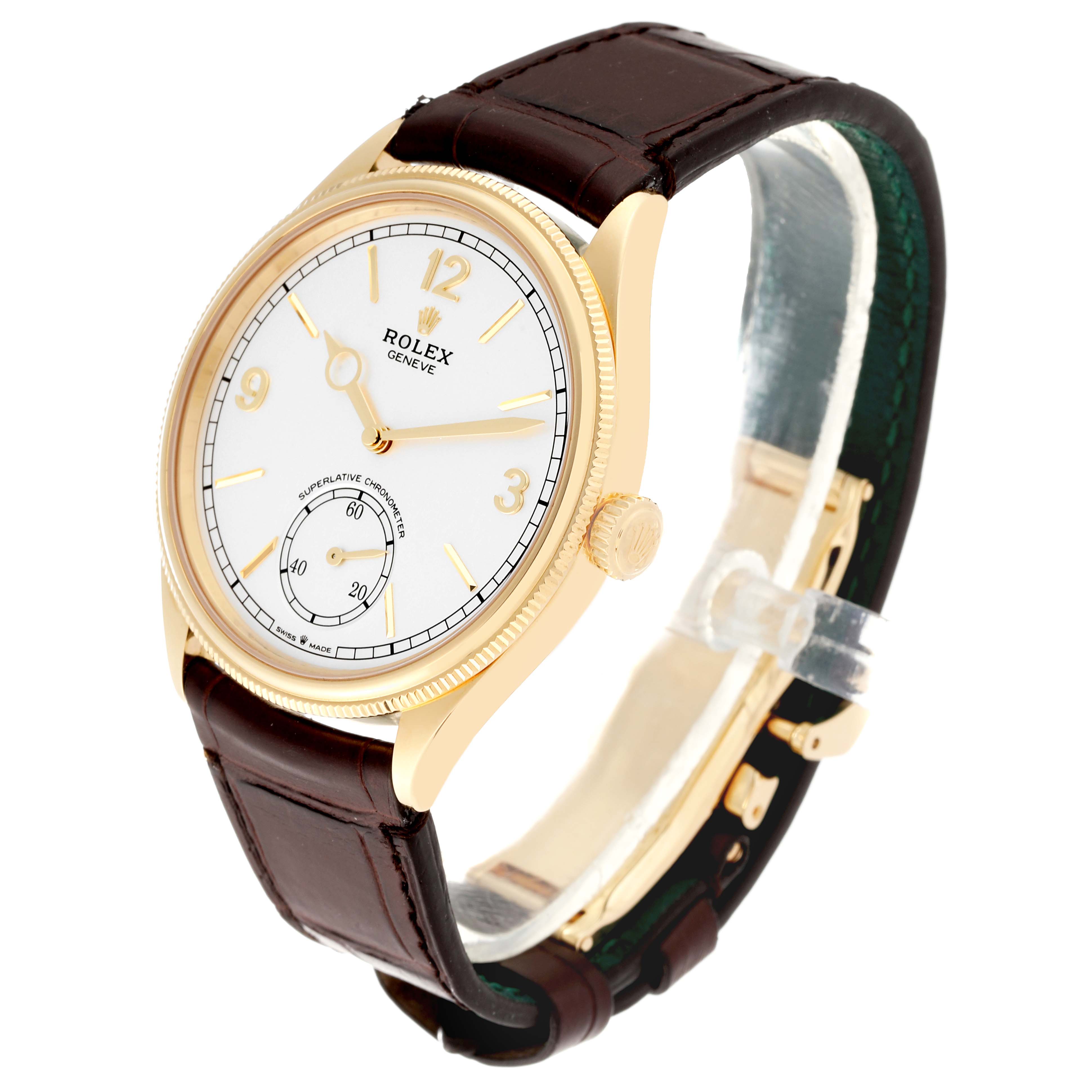 The Rolex Cellini watch is shown at a three-quarter angle, displaying its white dial, gold case, crown, and brown leather strap.