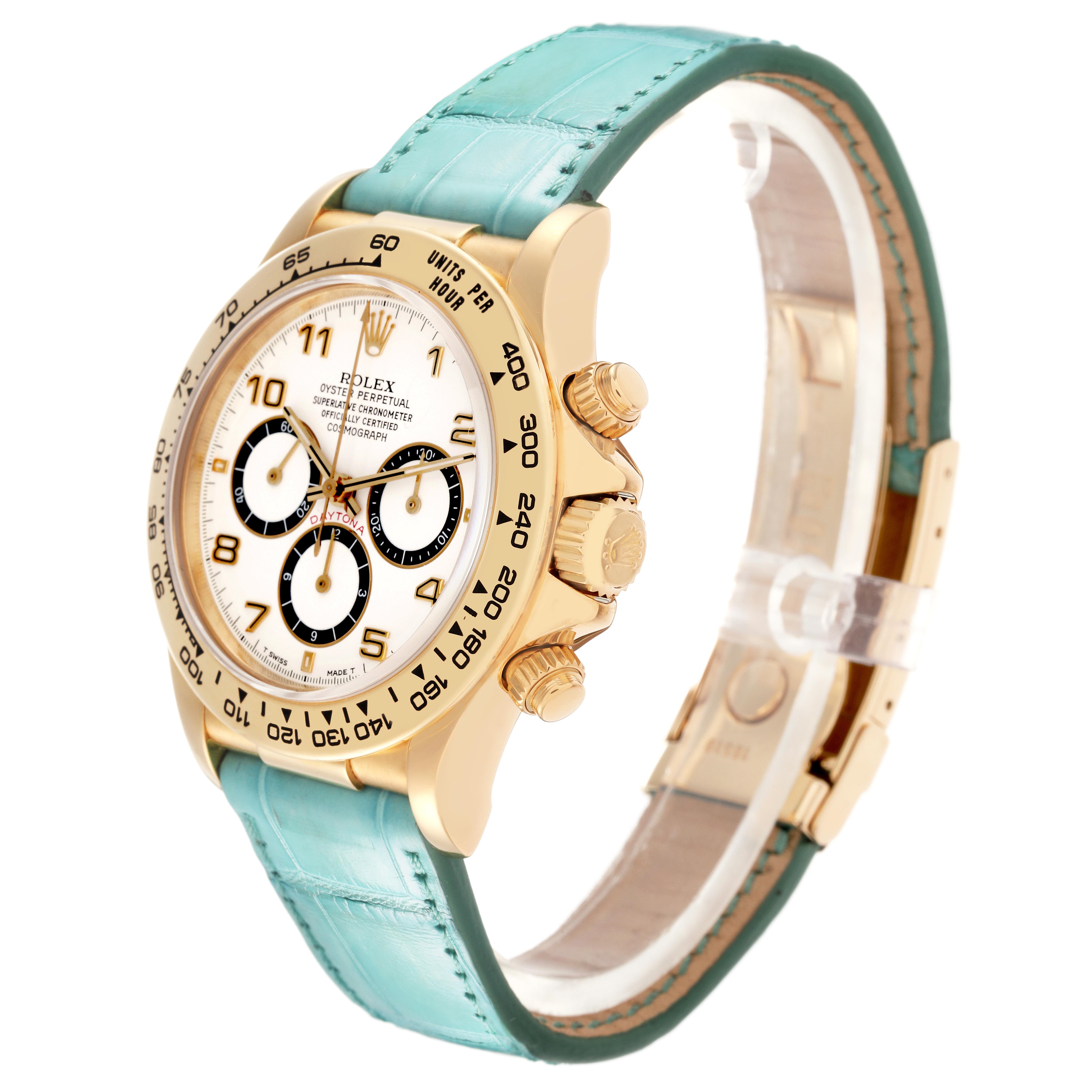 The Rolex Daytona 16518 Men
s Yellow Gold White Dial 16518 Men
s Yellow Gold White Dial watch is shown at a three-quarter angle, highlighting its dial, bezel, crown, and turquoise strap.