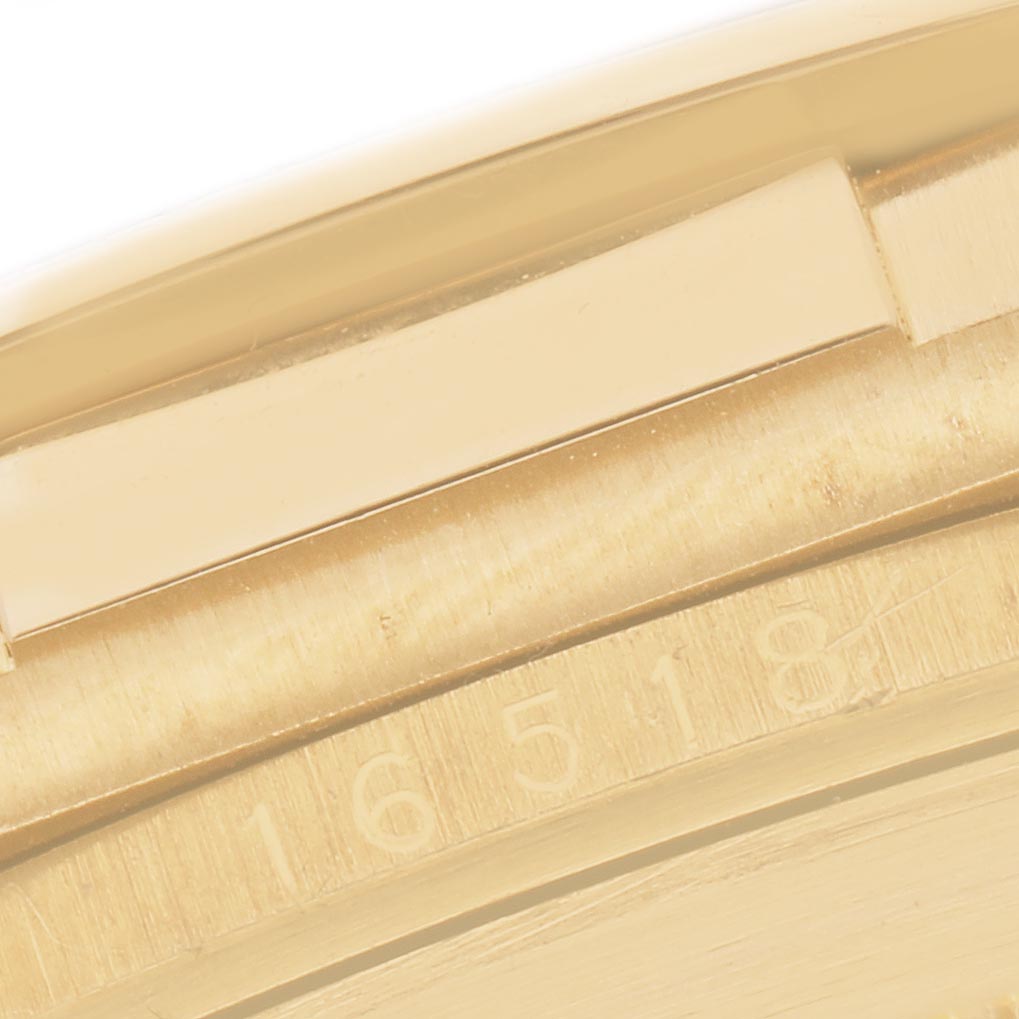 The image shows a close-up of the side or edge of the bezel and part of the case of a Rolex Daytona 16518 Men
s Yellow Gold White Dial 16518 Men
s Yellow Gold White Dial watch.