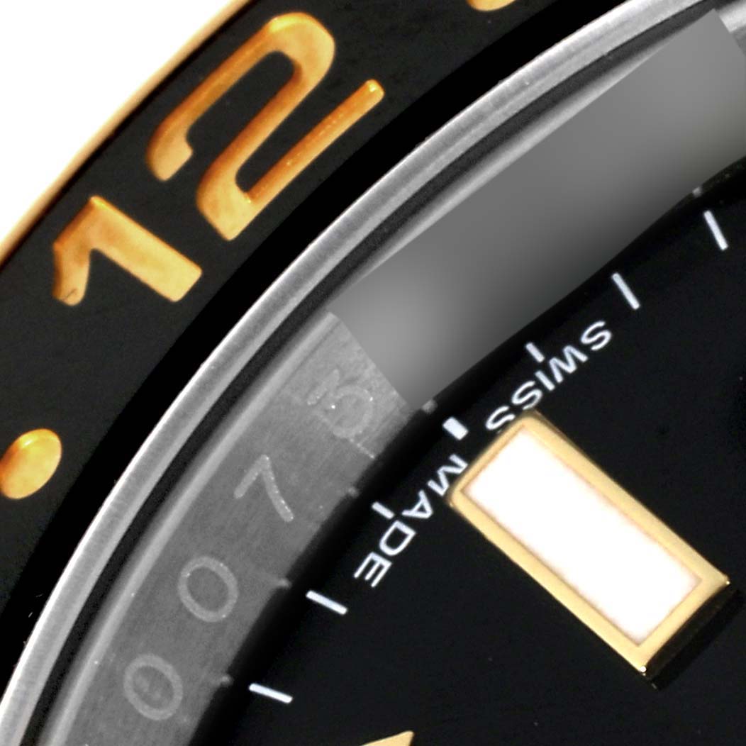 This close-up image shows the bezel and part of the dial of a Rolex GMT-Master 116713 Men's Steel and Gold (two tone) Black Dial 116713 Men's Steel and Gold (two tone) Black Dial watch, highlighting the numerals and markers.