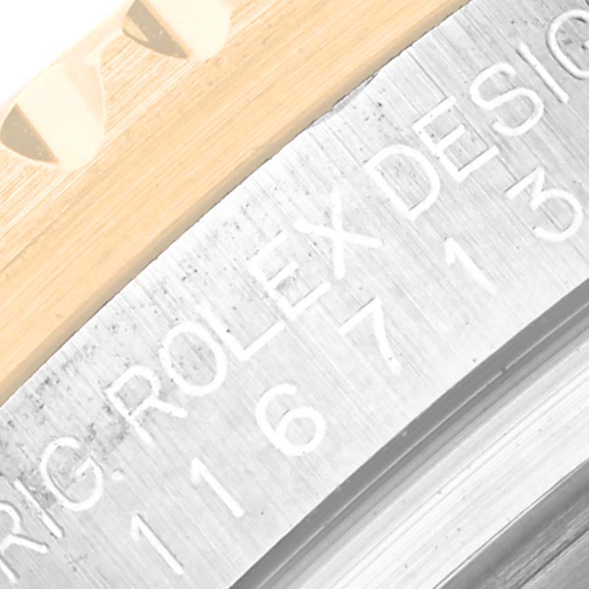 This close-up image shows the engraved serial number and part of the case back of the Rolex GMT-Master 116713 Men's Steel and Gold (two tone) Black Dial 116713 Men's Steel and Gold (two tone) Black Dial watch.