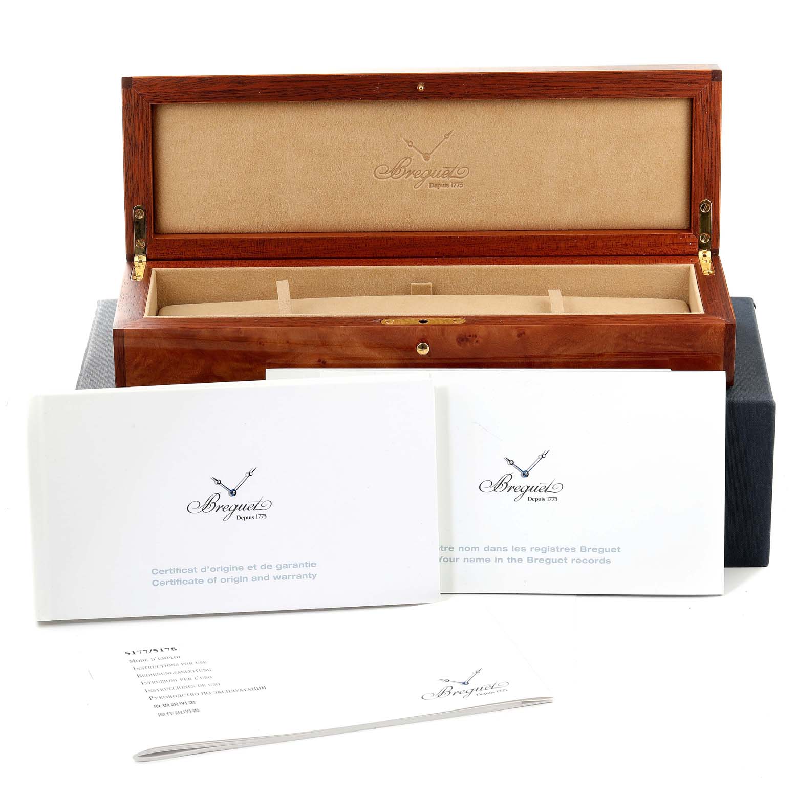 The image shows an open wooden box for the Classique model by Breguet, along with warranty and information booklets.