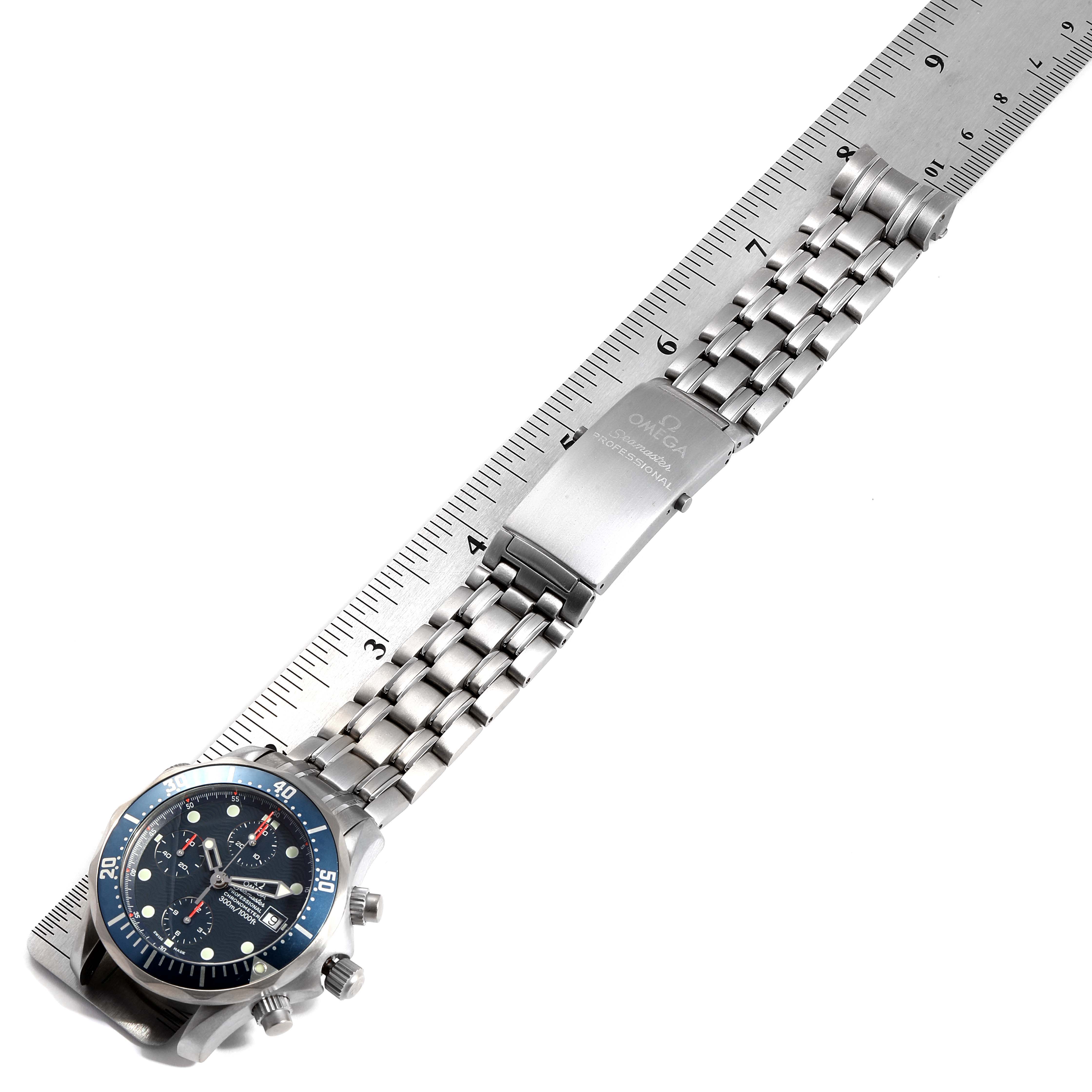 The image shows an Omega Seamaster 2298.80.00 Men
s Titanium Blue Dial 2298.80.00 Men
s Titanium Blue Dial watch laid flat against a ruler, highlighting its face, bracelet, and clasp.