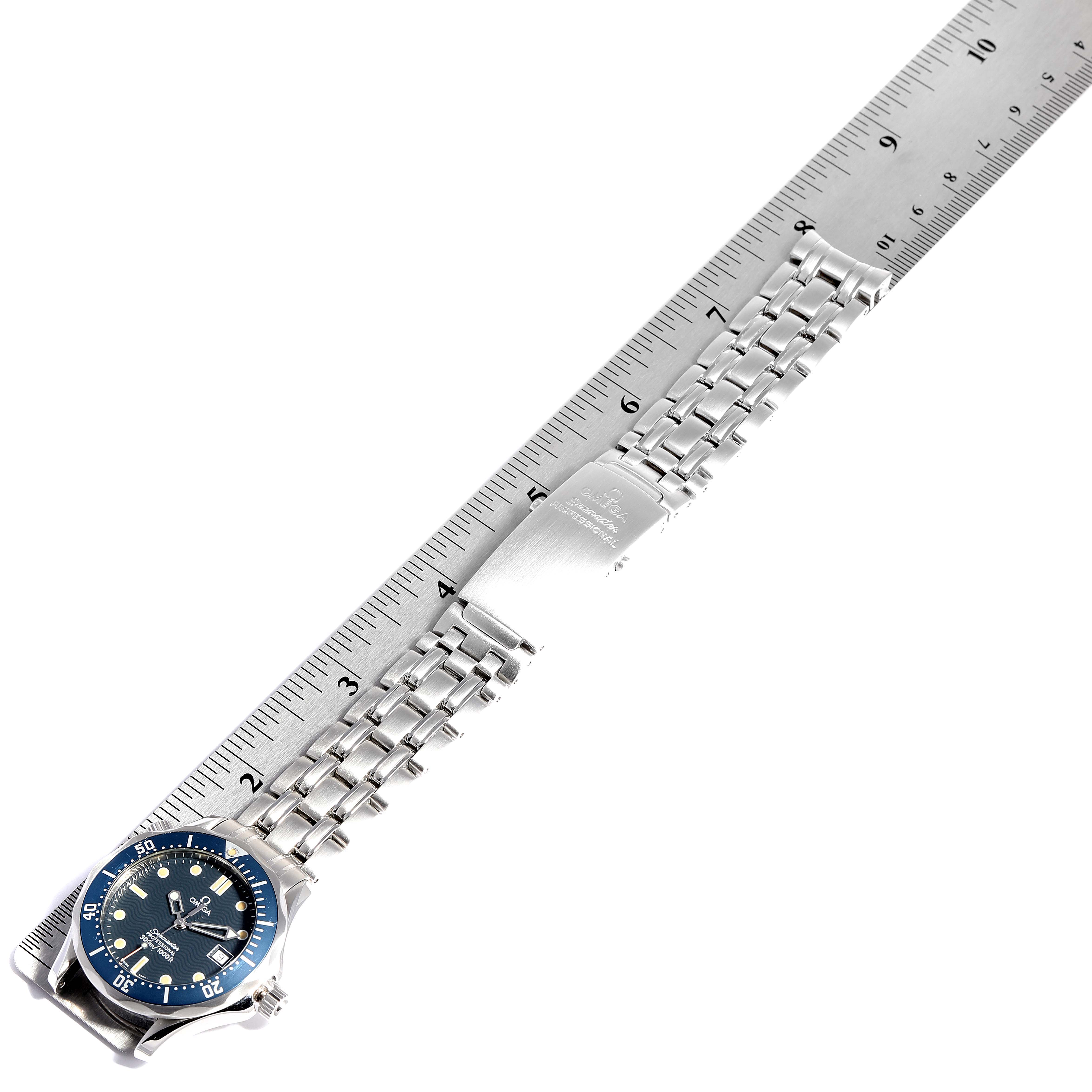 The image shows an Omega Seamaster 2561.80.00 Men
s Stainless Steel Blue Dial 2561.80.00 Men
s Stainless Steel Blue Dial watch laid flat next to a ruler, showcasing its face, bracelet, and clasp.