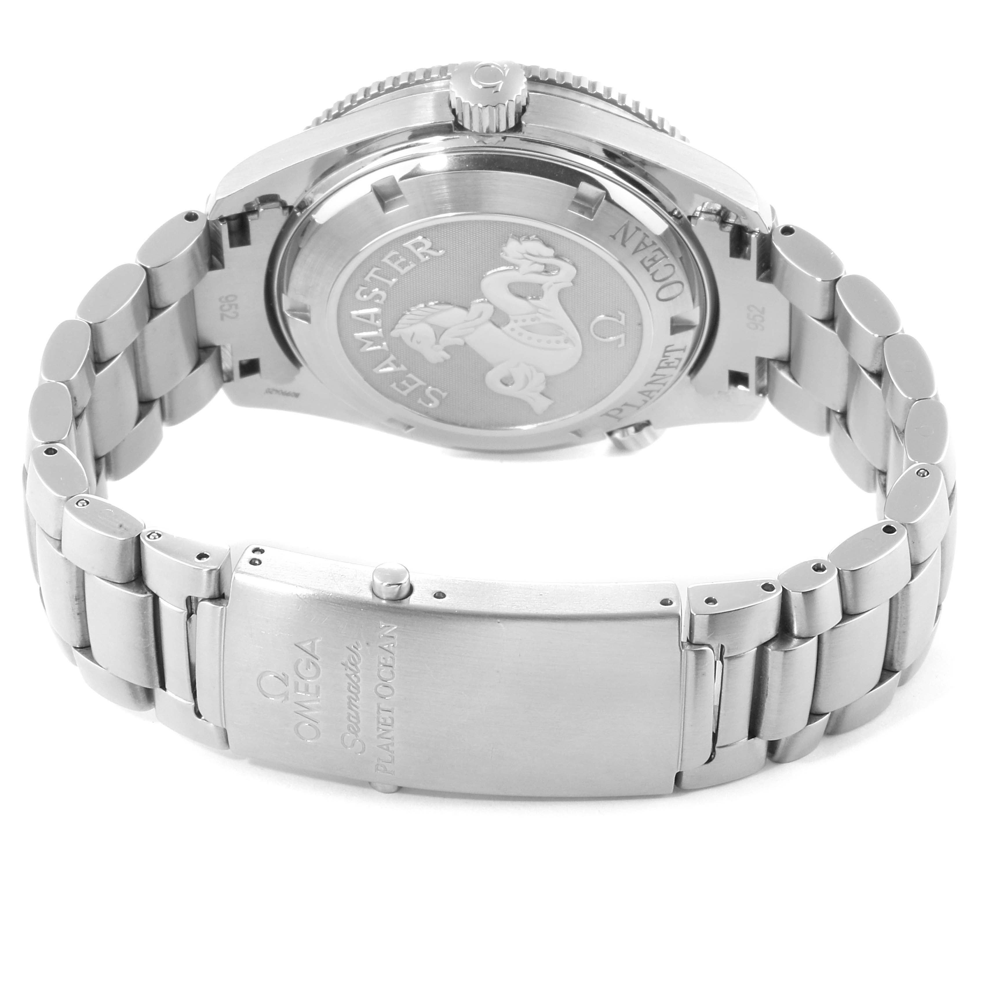 The image shows the back case, crown, and bracelet clasp of an Omega Seamaster Planet Ocean watch.