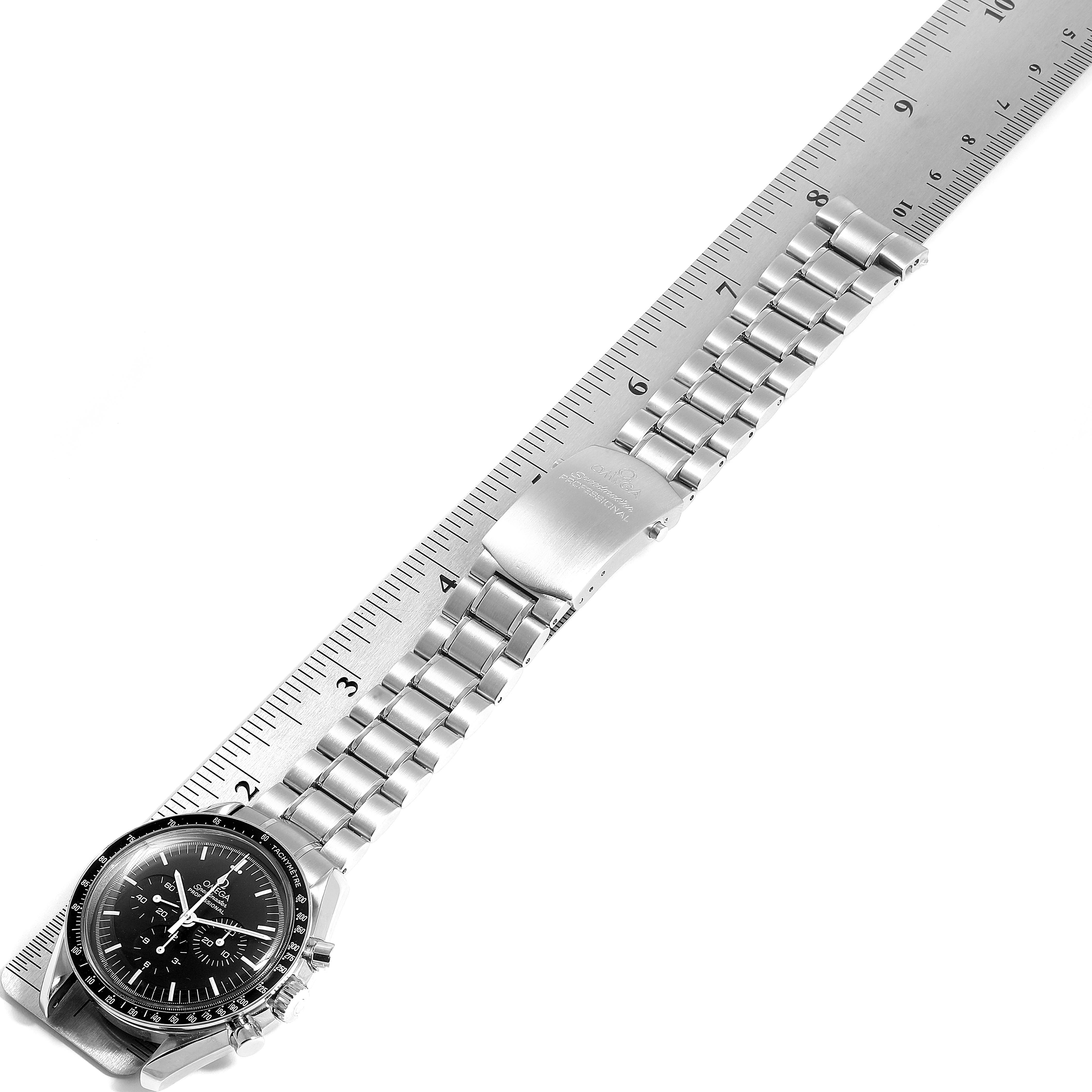 The image shows the Omega Speedmaster 3570.50.00 Men
s Stainless Steel Black Dial 3570.50.00 Men
s Stainless Steel Black Dial watch laid flat with a ruler measuring its metal bracelet.
