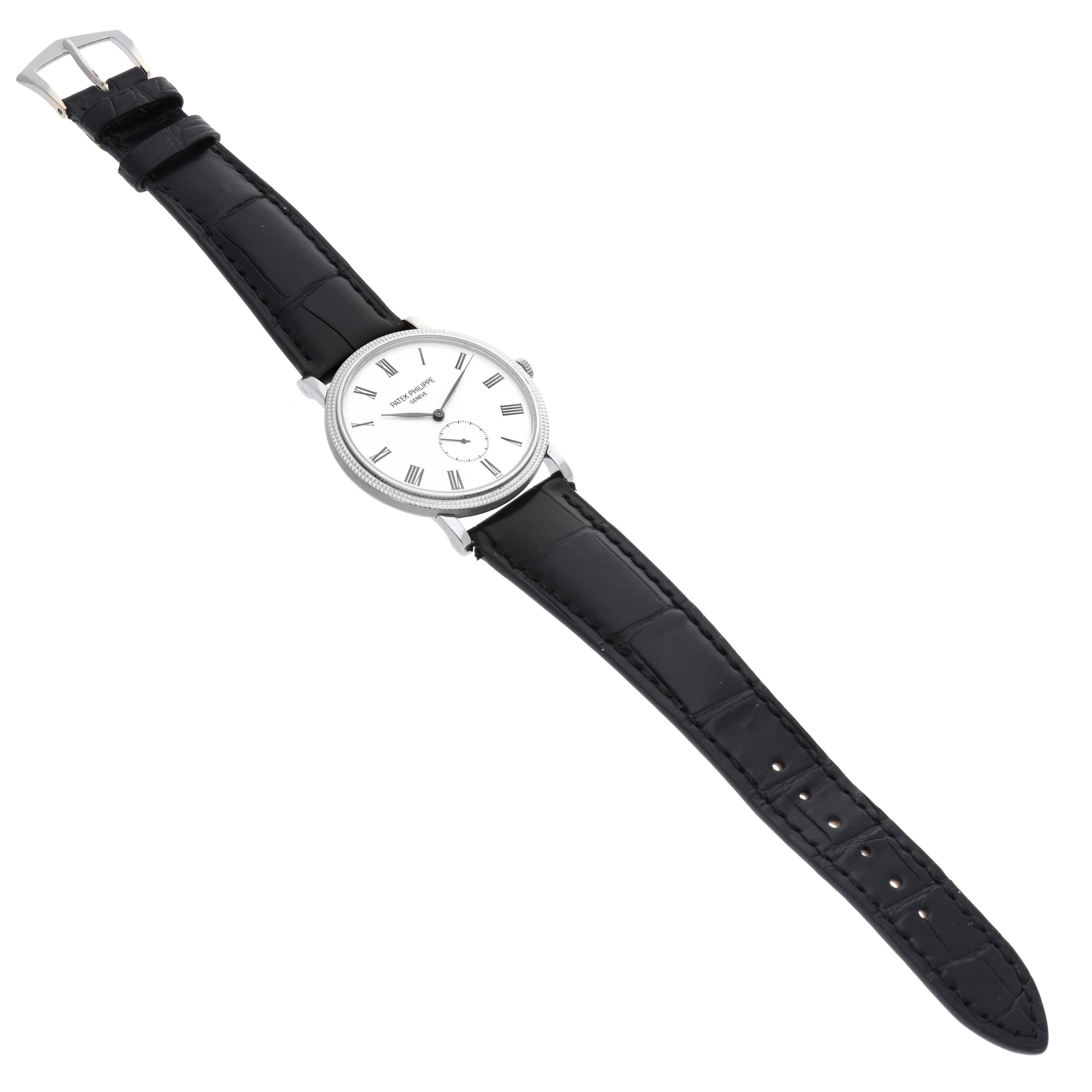 This image shows a Patek Philippe Calatrava 5116G Men
s White Gold White Dial 5116G Men
s White Gold White Dial watch from a top-down angle, displaying its face, black leather strap, and buckle.