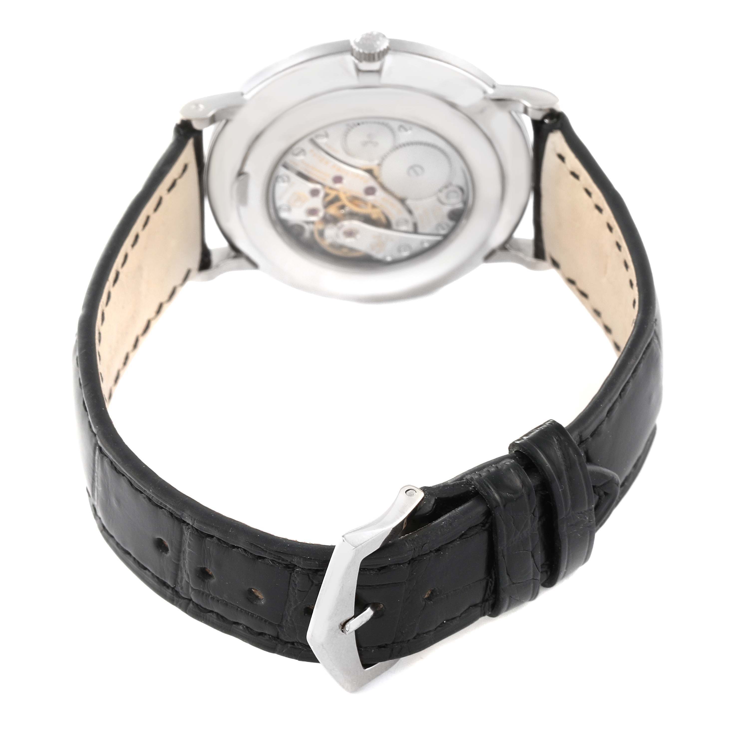 The image shows the back view of a Patek Philippe Calatrava 5116G Men
s White Gold White Dial 5116G Men
s White Gold White Dial watch, featuring the movement and a black leather strap with a buckle.