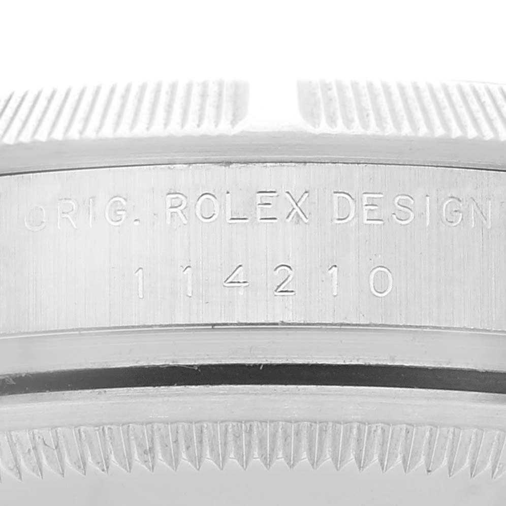 The image shows a close-up of the side of the Rolex Air-King 114210 Men's Stainless Steel Silver Dial 114210 Men's Stainless Steel Silver Dial model, featuring the model number and the branded engraving.