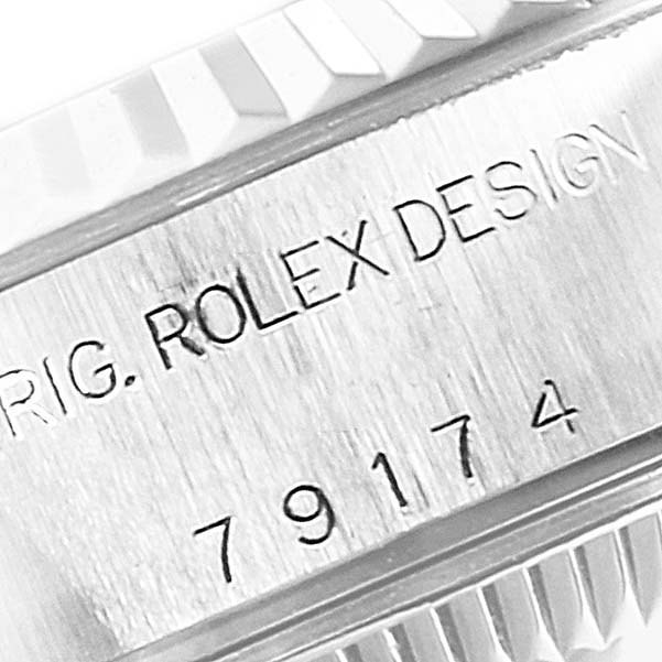 The image shows a close-up view of the casing with engraved text on a Rolex Datejust 79174 Women's Stainless Steel Blue Dial 79174 Women's Stainless Steel Blue Dial watch, featuring partial serial and model numbers.